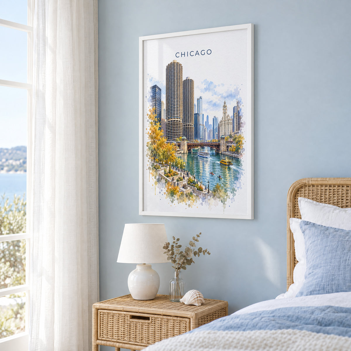 Chicago Riverwalk watercolor print in a white frame on a pale blue wall beside a rattan bed in a coastal bedroom