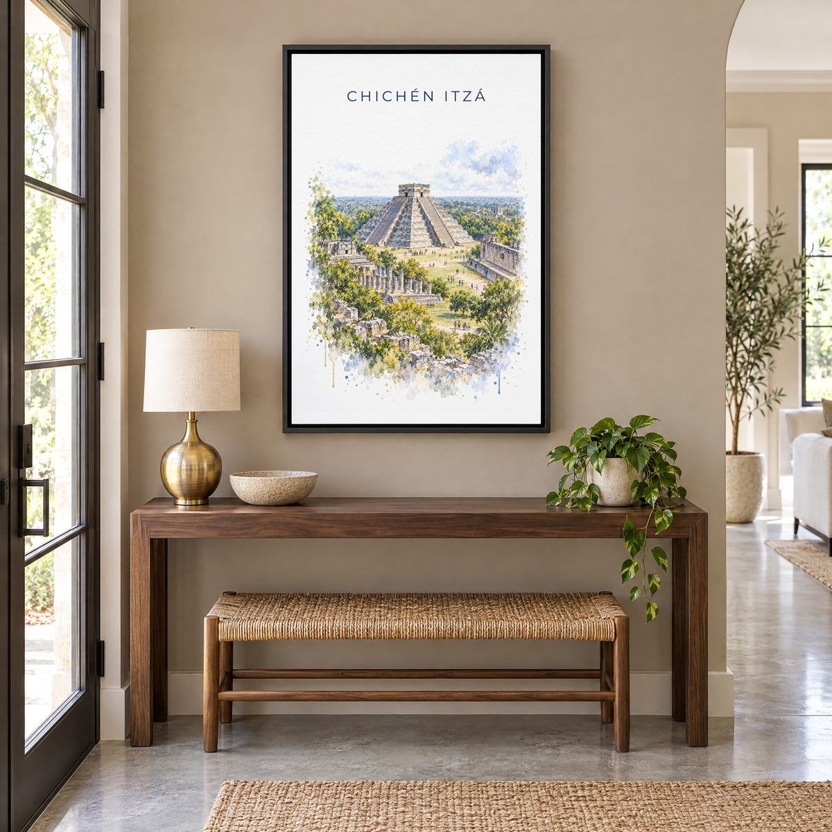 Chichen Itza watercolor print as a black floater canvas above a walnut console and woven bench in an entryway