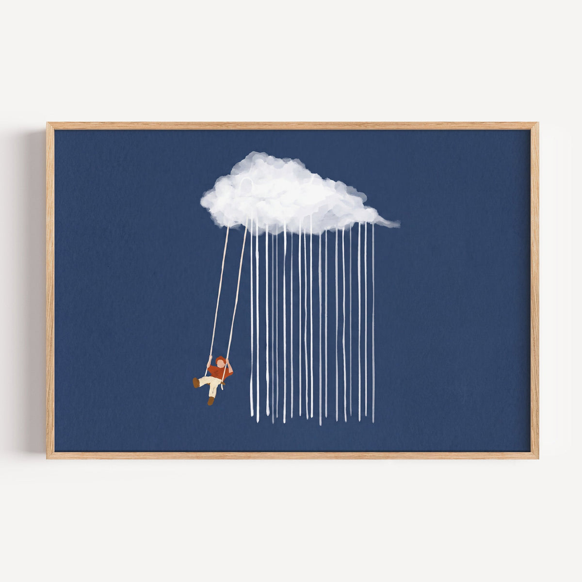 Child on a rain cloud swing print in a light oak frame on a plain white wall