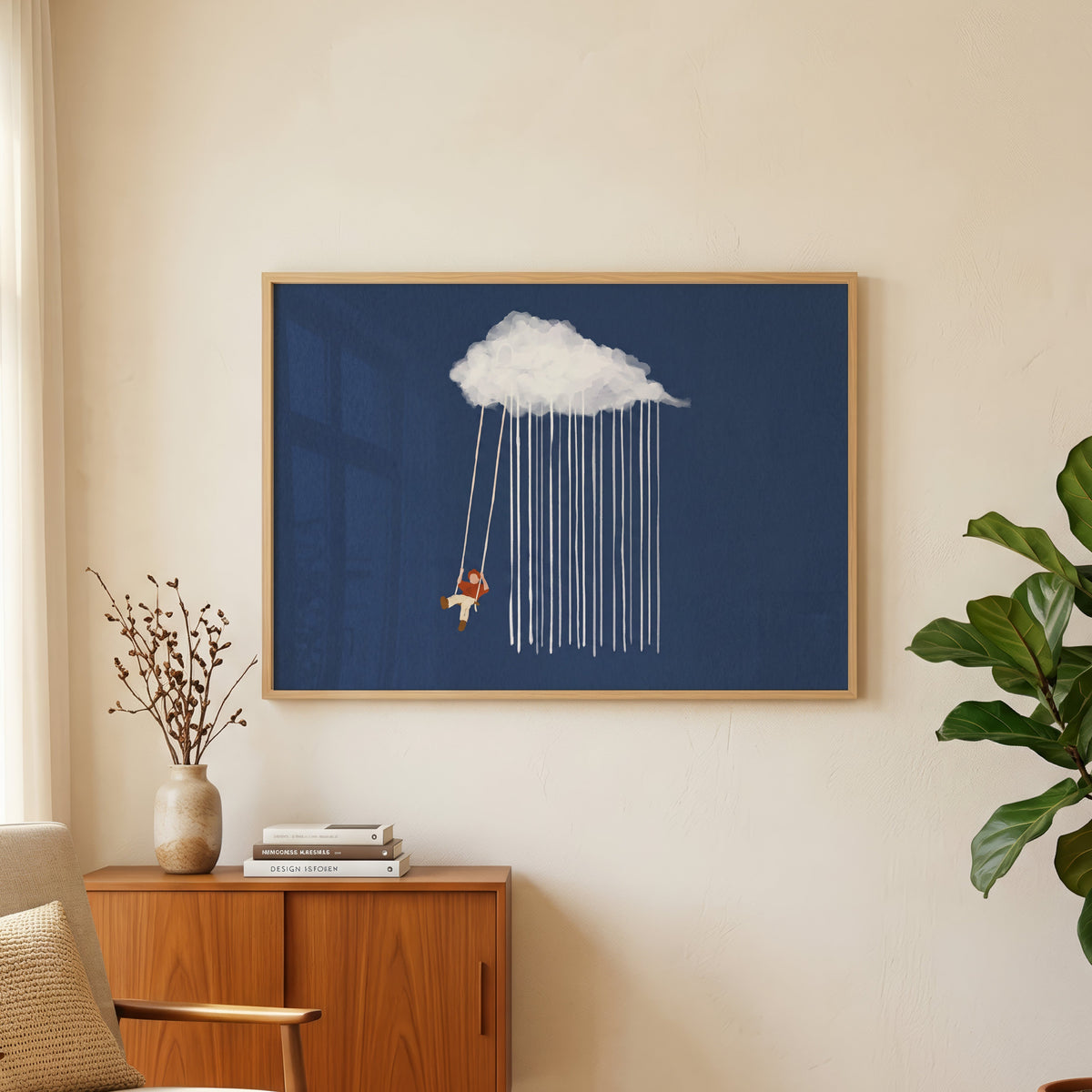 Blue rain cloud wall art print in an oak frame above a teak sideboard beside a fig tree