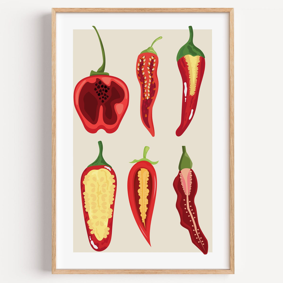 six sliced chili pepper cross sections print in a light oak frame on a plain white wall