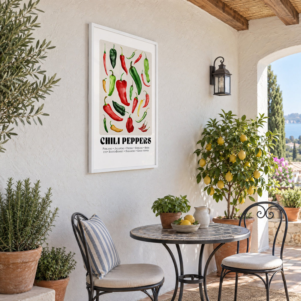 CHILI PEPPERS watercolor varieties print in a white frame on a sunny patio wall beside a potted lemon tree