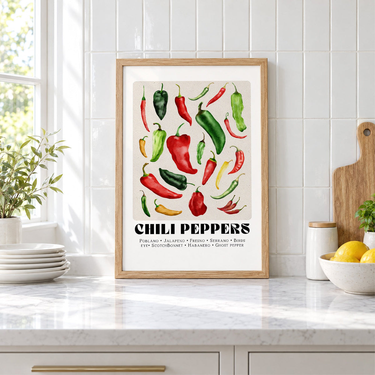 CHILI PEPPERS watercolor varieties print in an oak frame leaning on a marble counter by white tiles and lemons