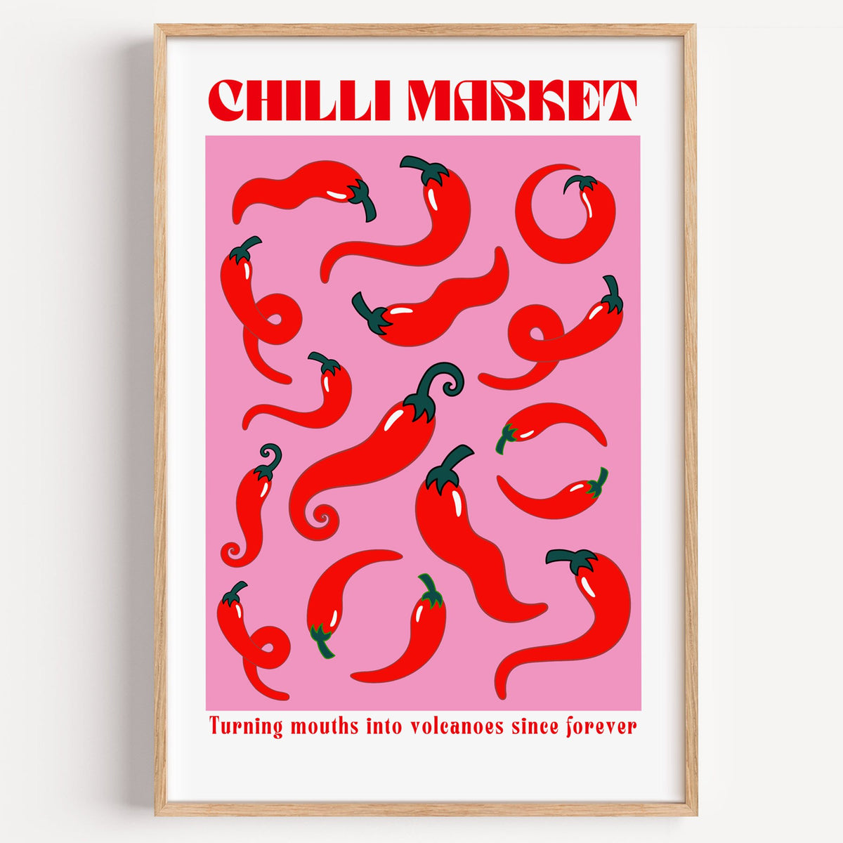 Chilli Market curly peppers print in a light oak frame on a plain white wall