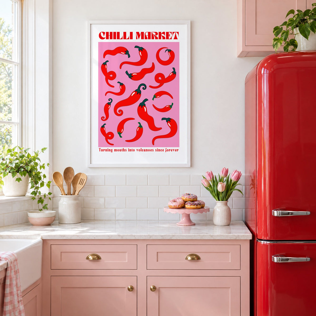 Chilli Market curly peppers print in a white frame in a pink kitchen beside a red retro fridge