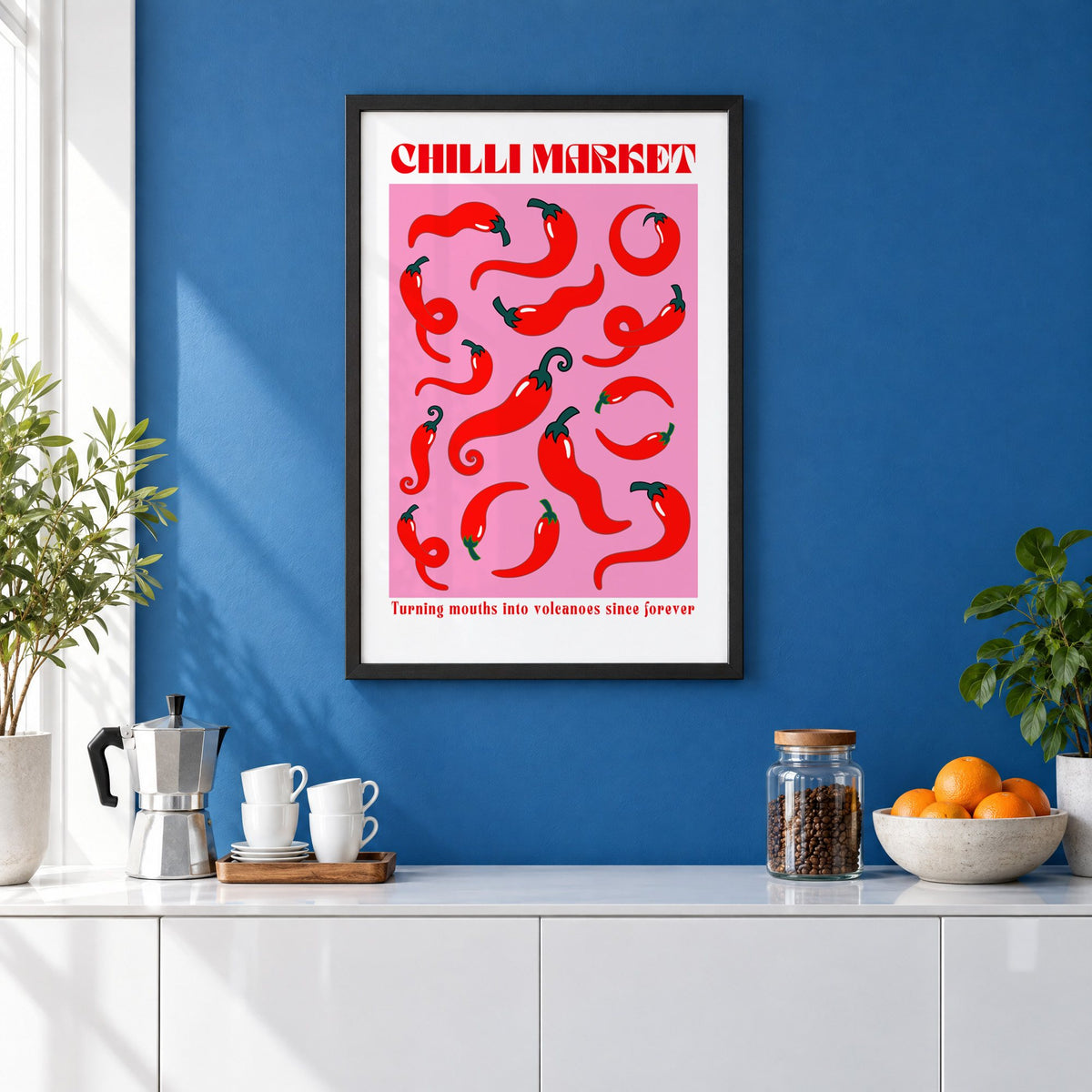Chilli Market curly peppers print in a black frame on a cobalt blue wall above a coffee station
