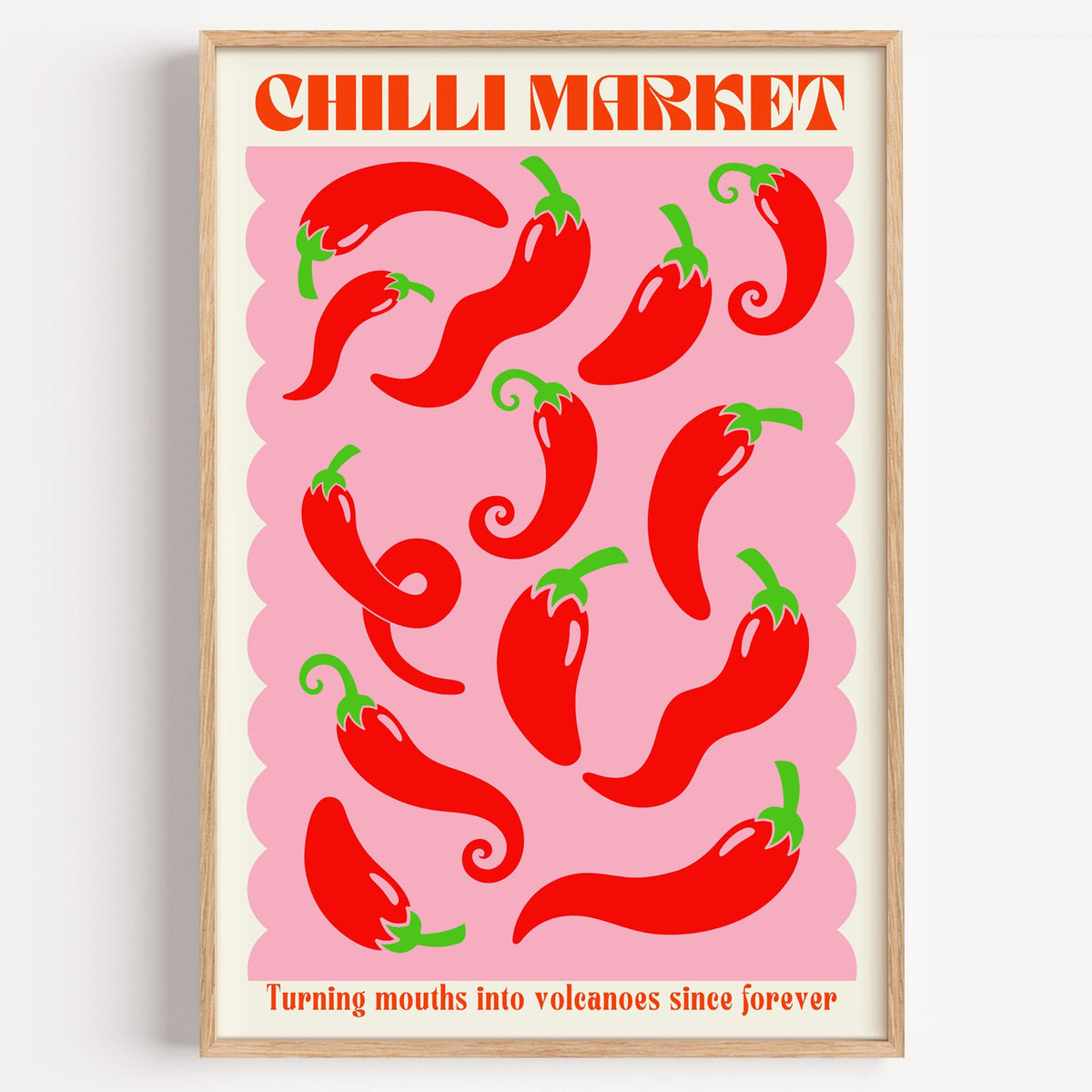 CHILLI MARKET red peppers pink scallop print in a light oak frame on a plain white wall