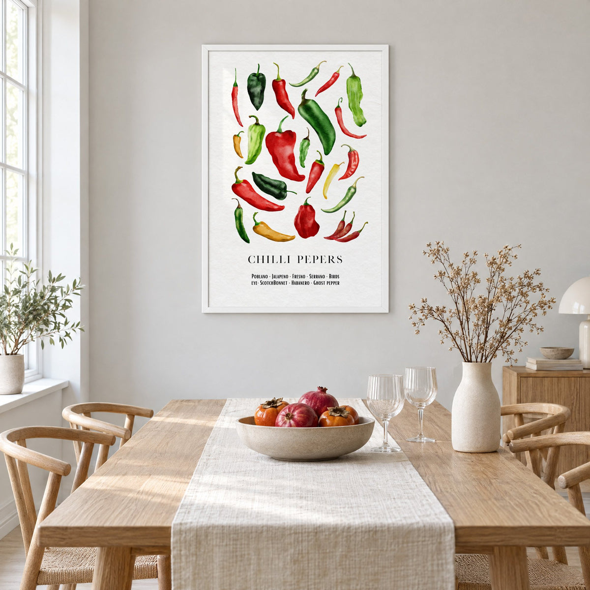 CHILLI PEPERS watercolor pepper varieties print in a white frame above a light oak dining table with a linen runner and fruit bowl