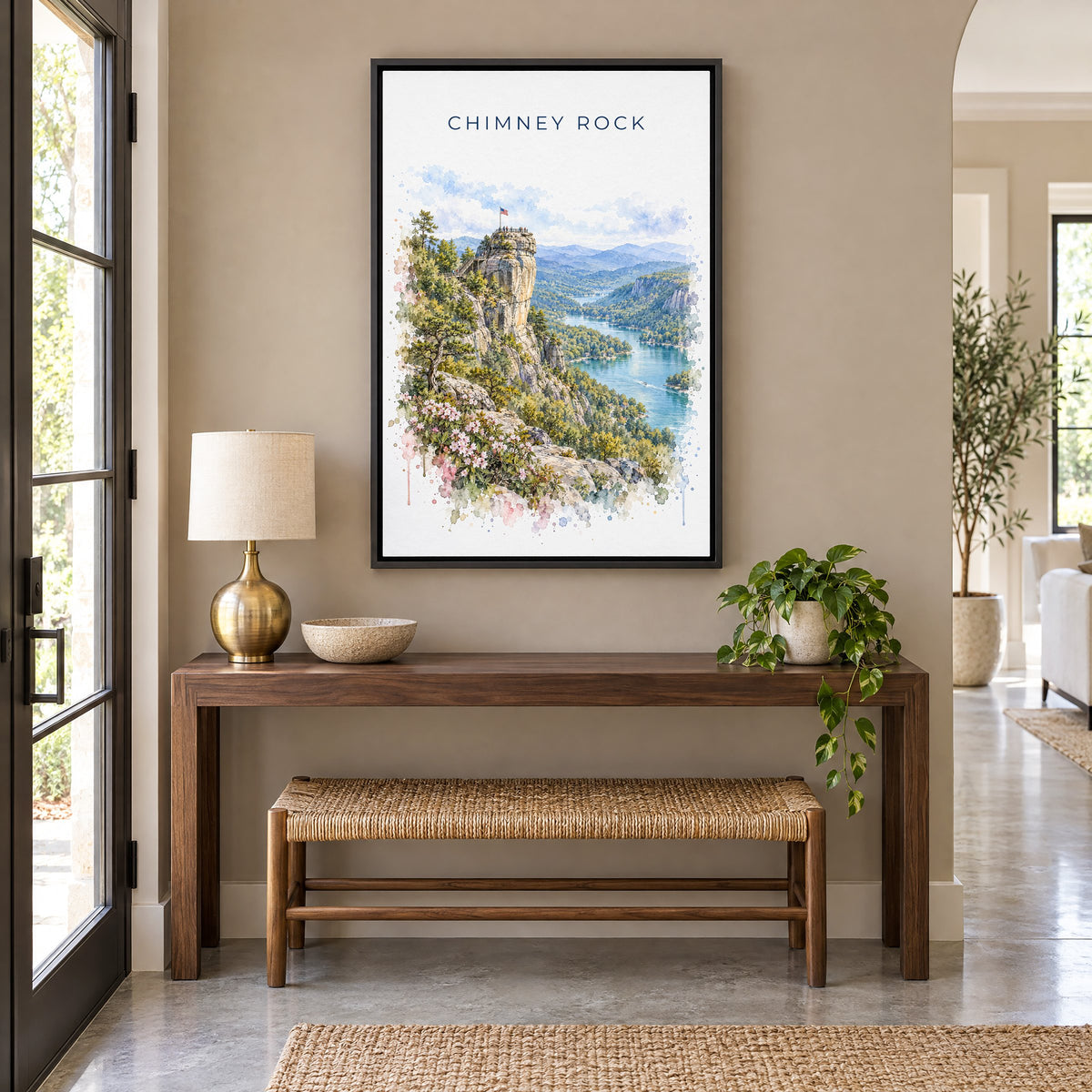 Chimney Rock, North Carolina watercolor print as a black floater canvas above a walnut console and woven bench in an entryway