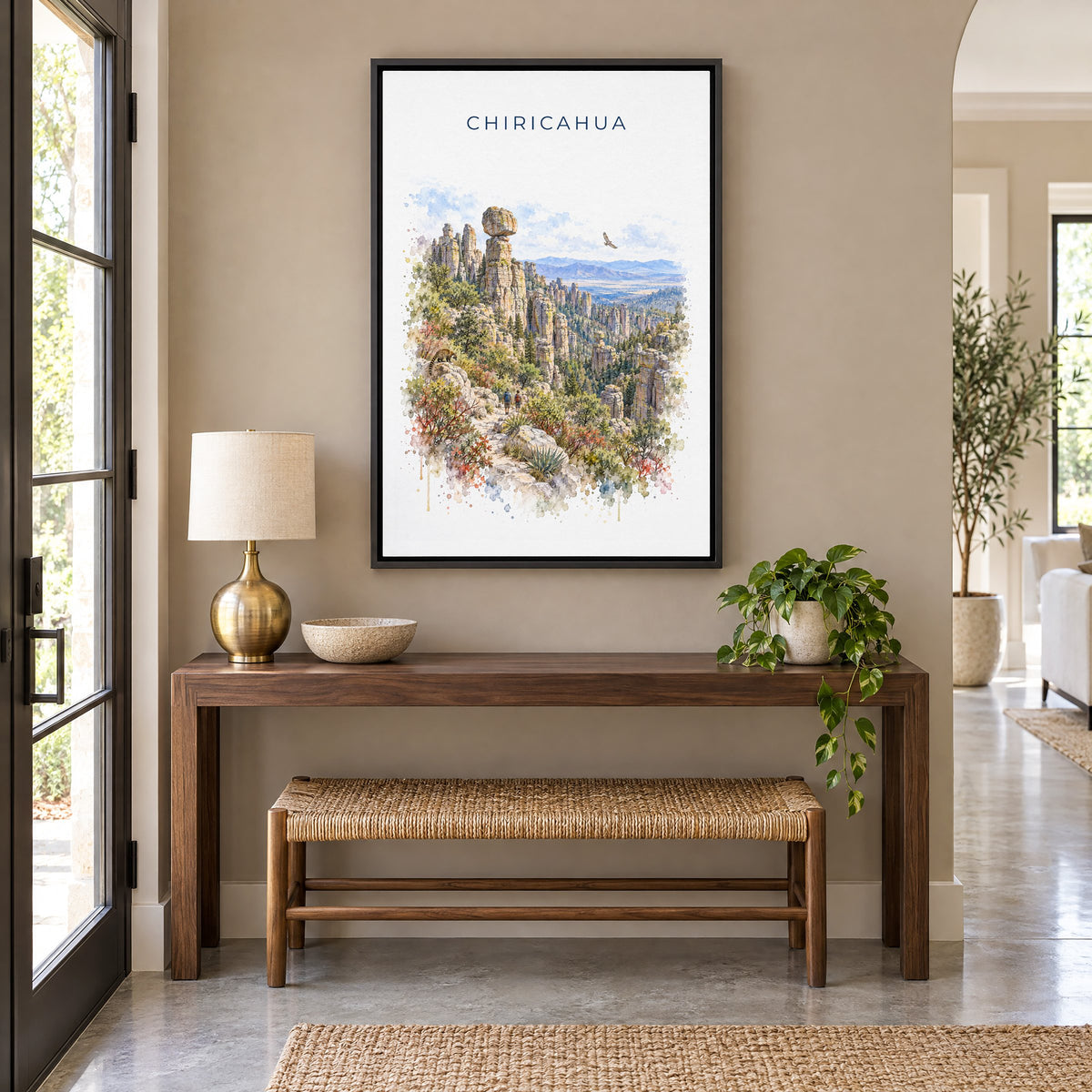 Chiricahua National Park watercolor print as a black floater canvas above a walnut console and woven bench in an entryway
