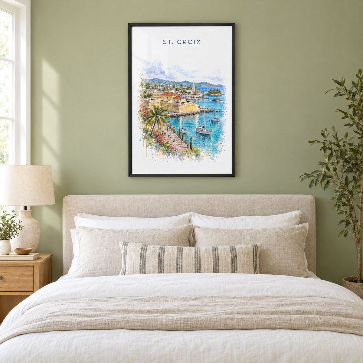 St. Croix watercolor print in a black frame above an upholstered headboard in a sage green bedroom