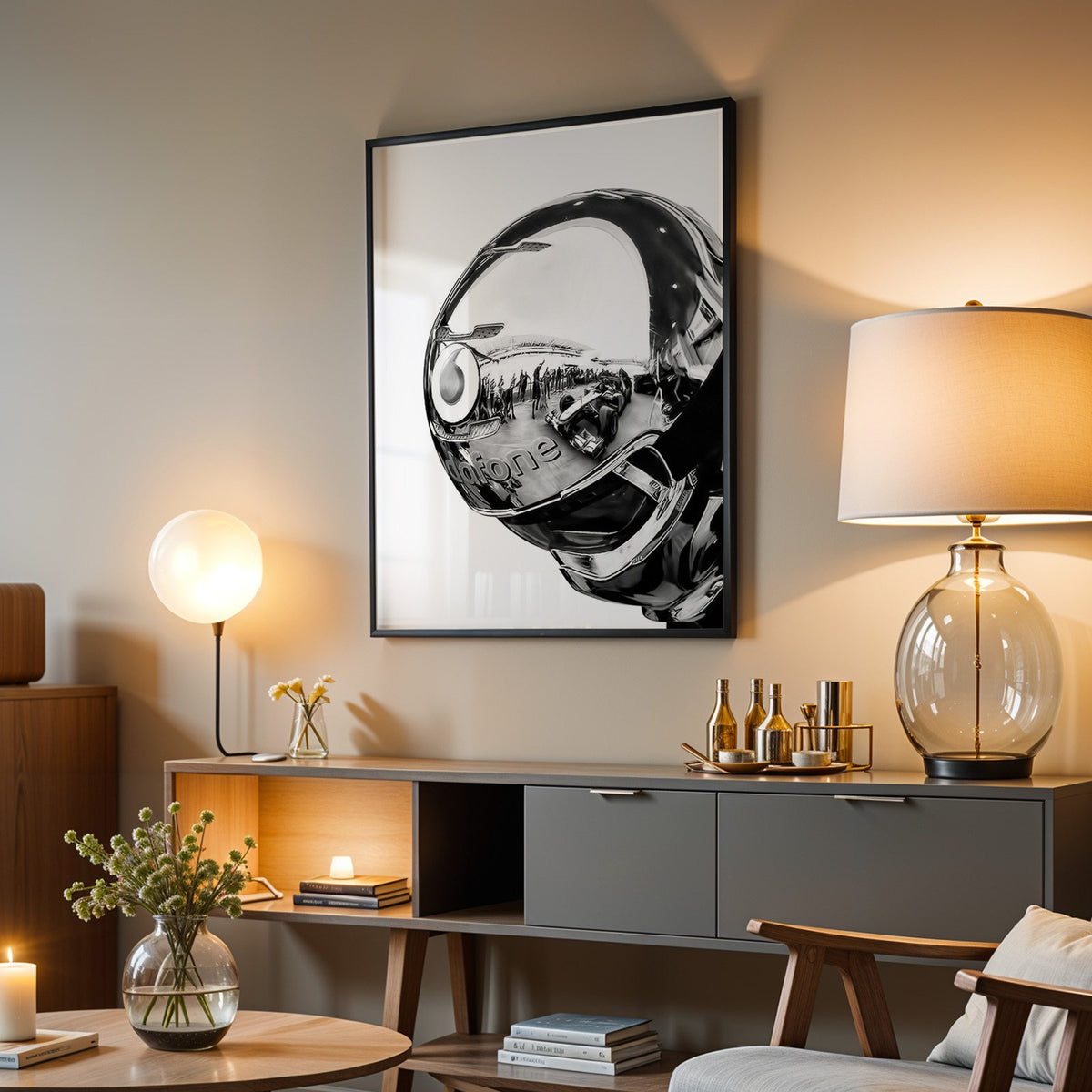 Chrome racing helmet with reflected race cars print in a black frame above a grey media console with a glass table lamp
