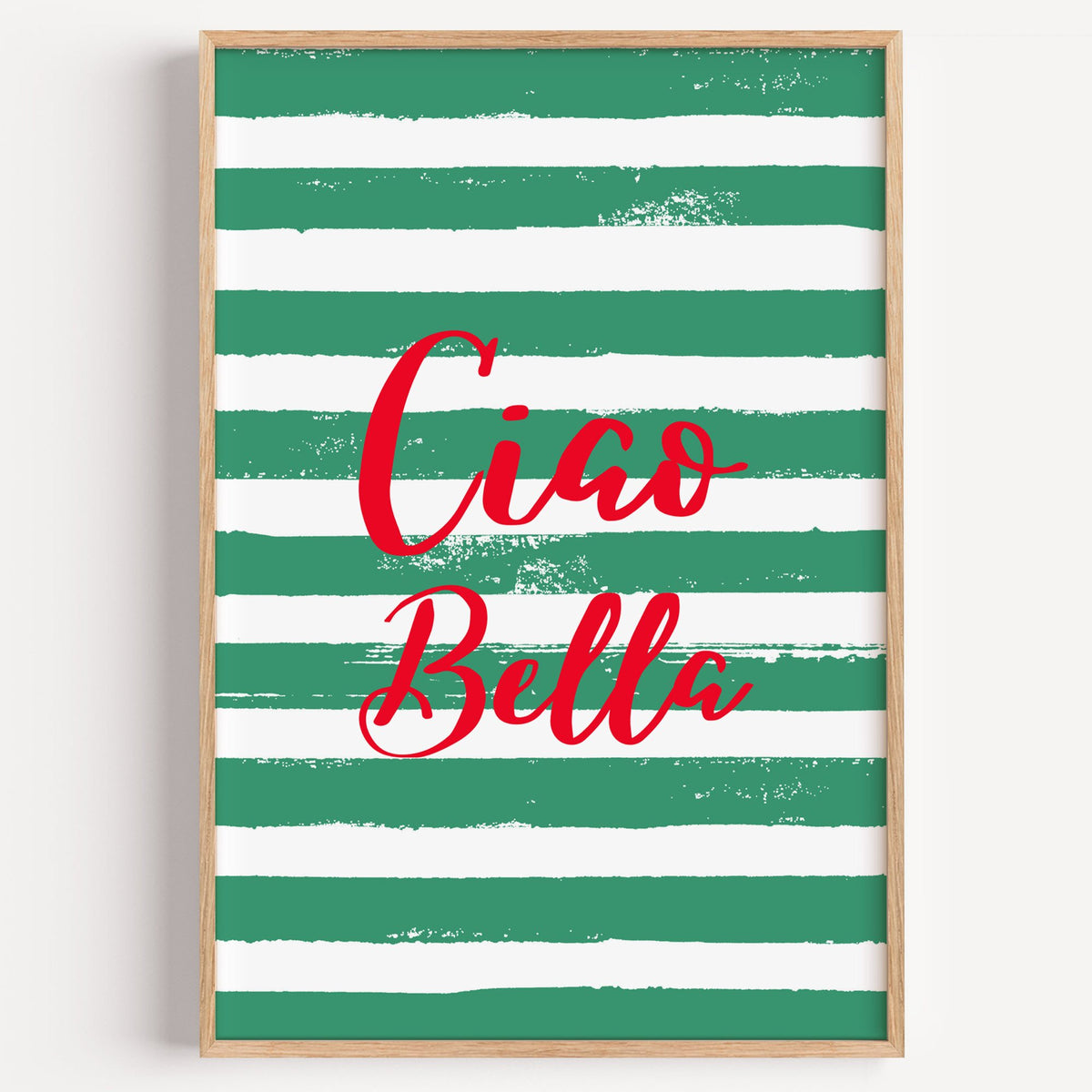 Ciao Bella red script on green stripes print in a light oak frame on a plain white wall