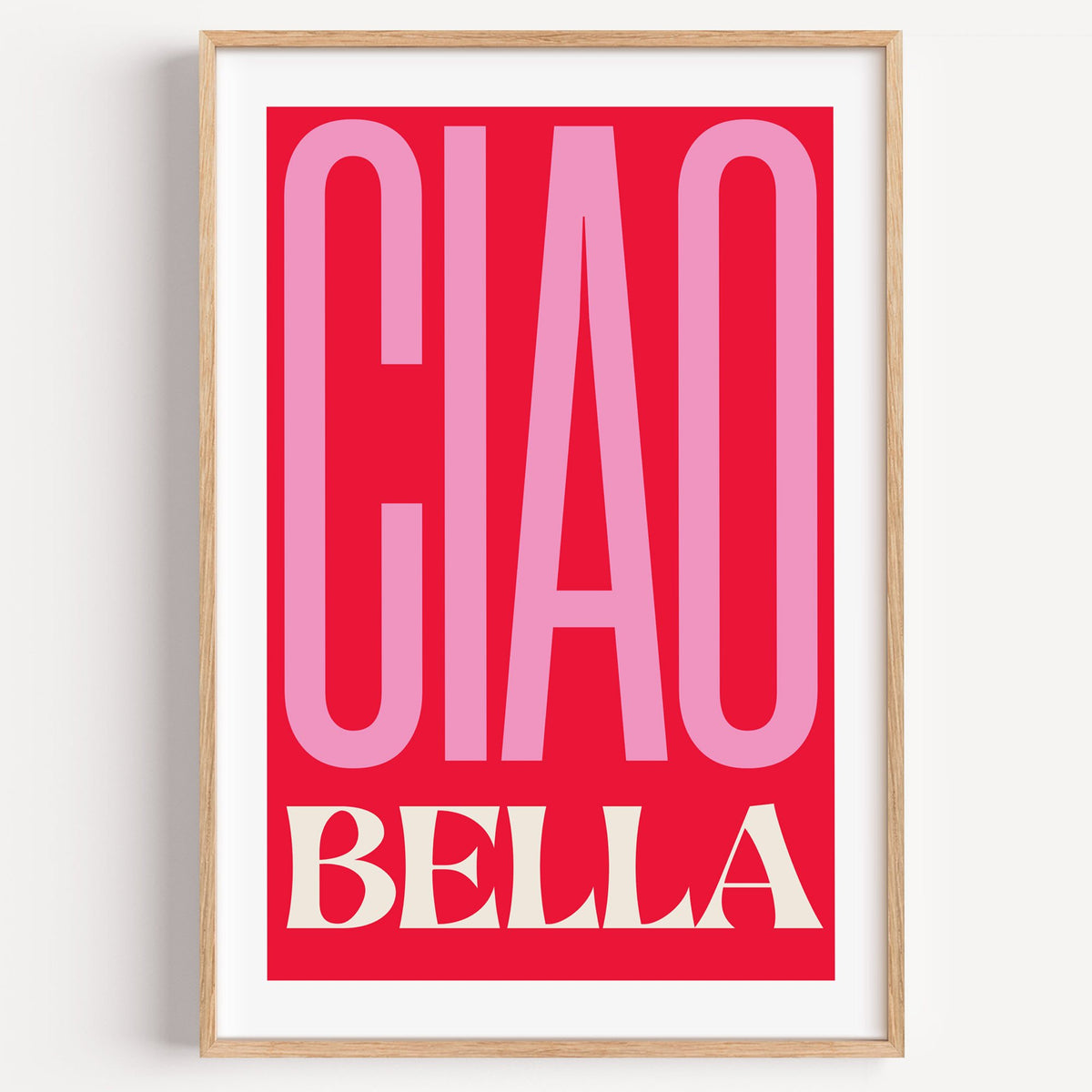 Ciao Bella pink and red type print in a light oak frame on a plain white wall