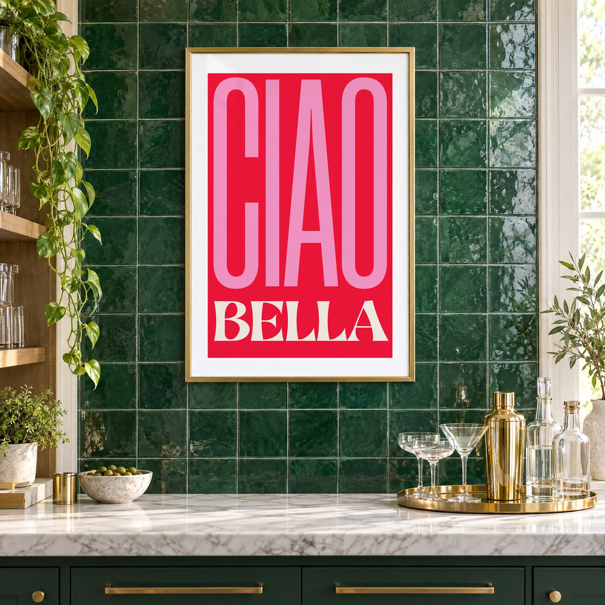Ciao Bella pink and red type print in a brass frame on emerald green tiles above a home bar with coupe glasses