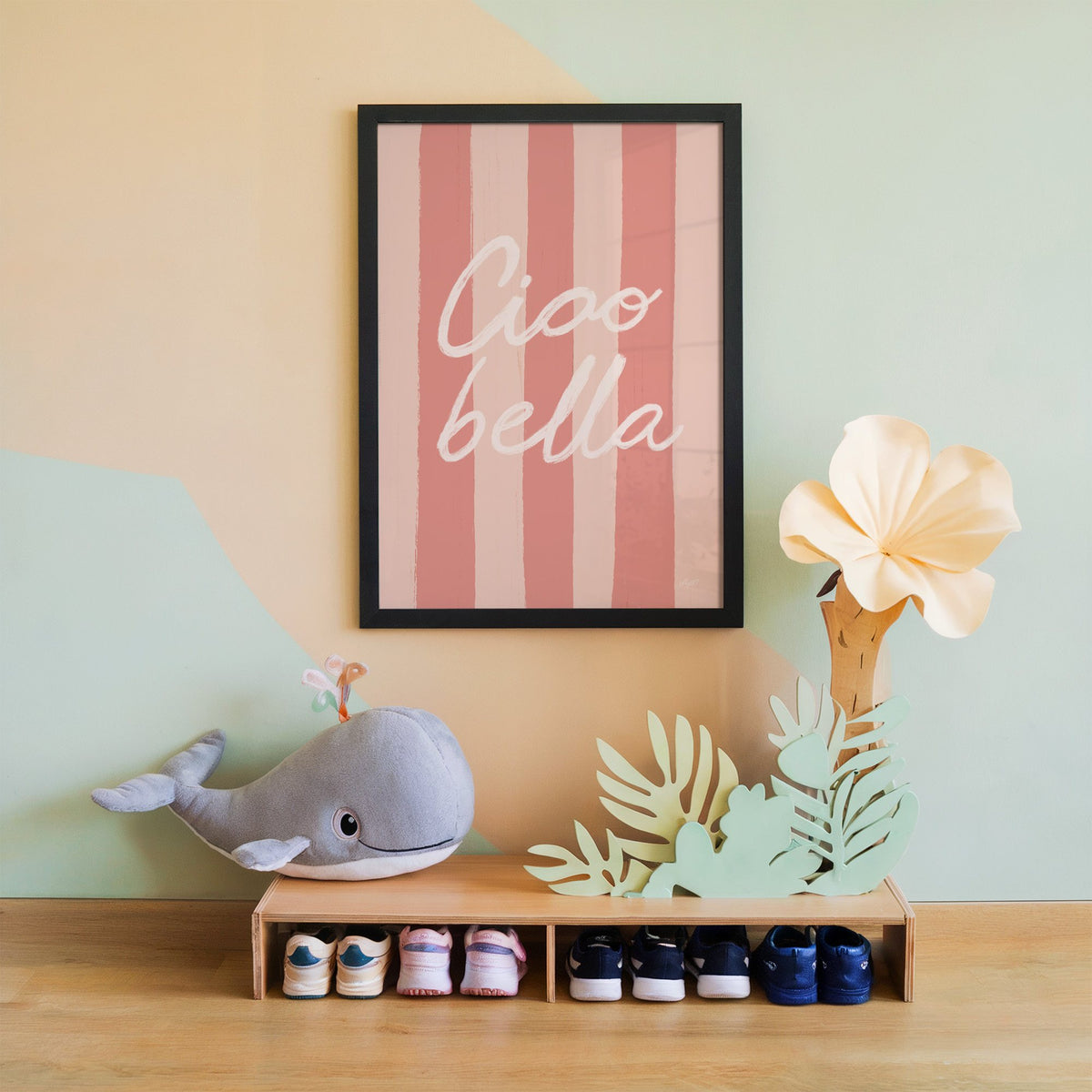 Ciao bella script on pink stripes nursery print in a black frame on a mint and peach wall above a whale plush