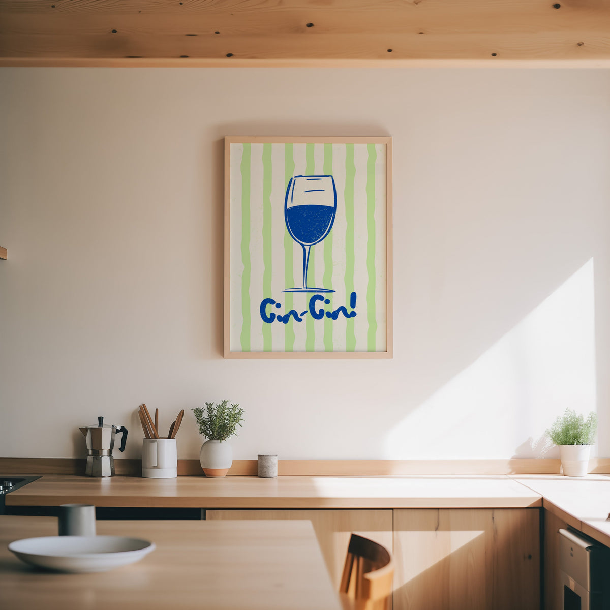 Cin Cin blue glass print in an oak frame above a wood counter with a moka pot and herbs