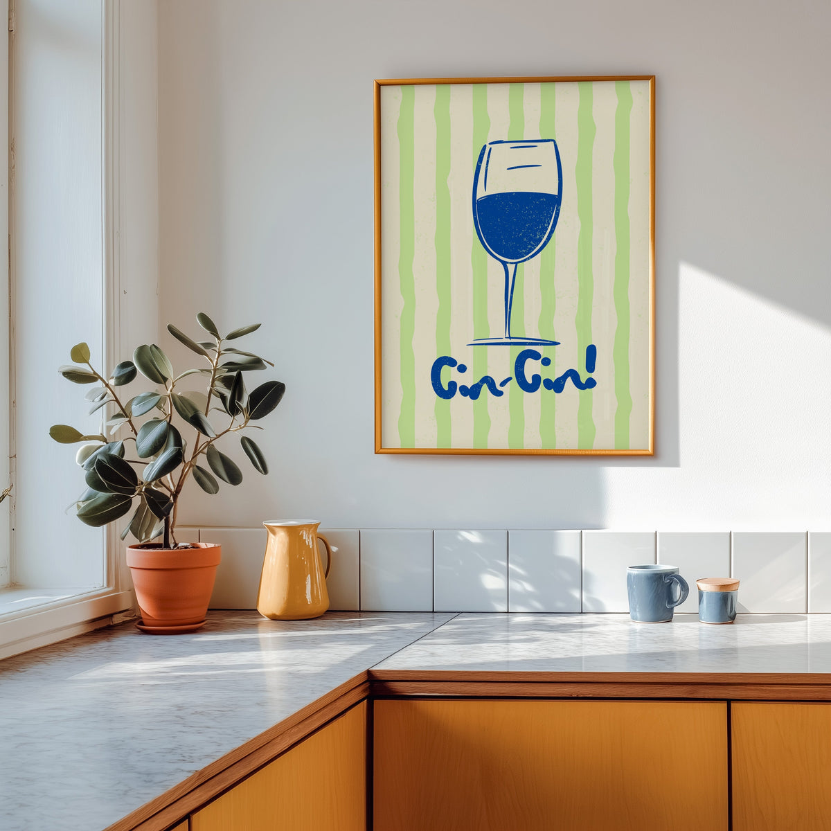 Cin Cin blue glass print shown in a gold frame above a marble counter with a yellow ceramic jug
