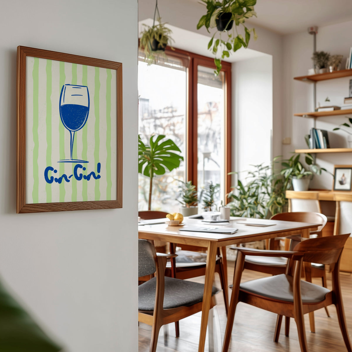 Cin Cin blue glass print in a walnut frame beside a mid-century dining table
