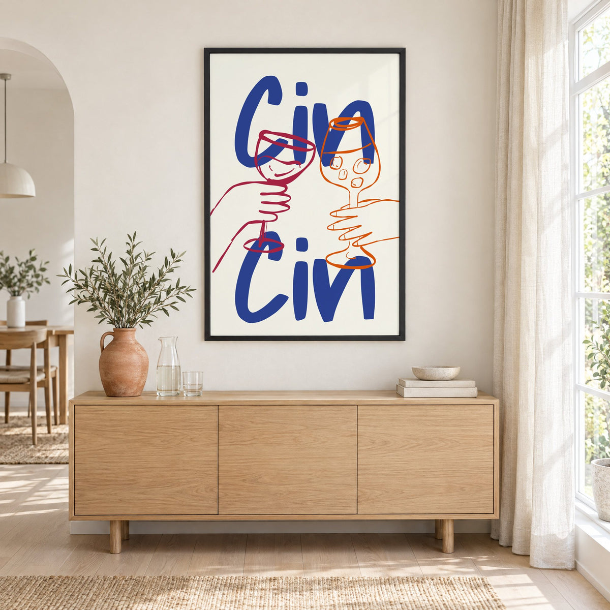 Cin Cin cobalt blue toast print in a black frame above an oak sideboard with a terracotta vase of olive branches