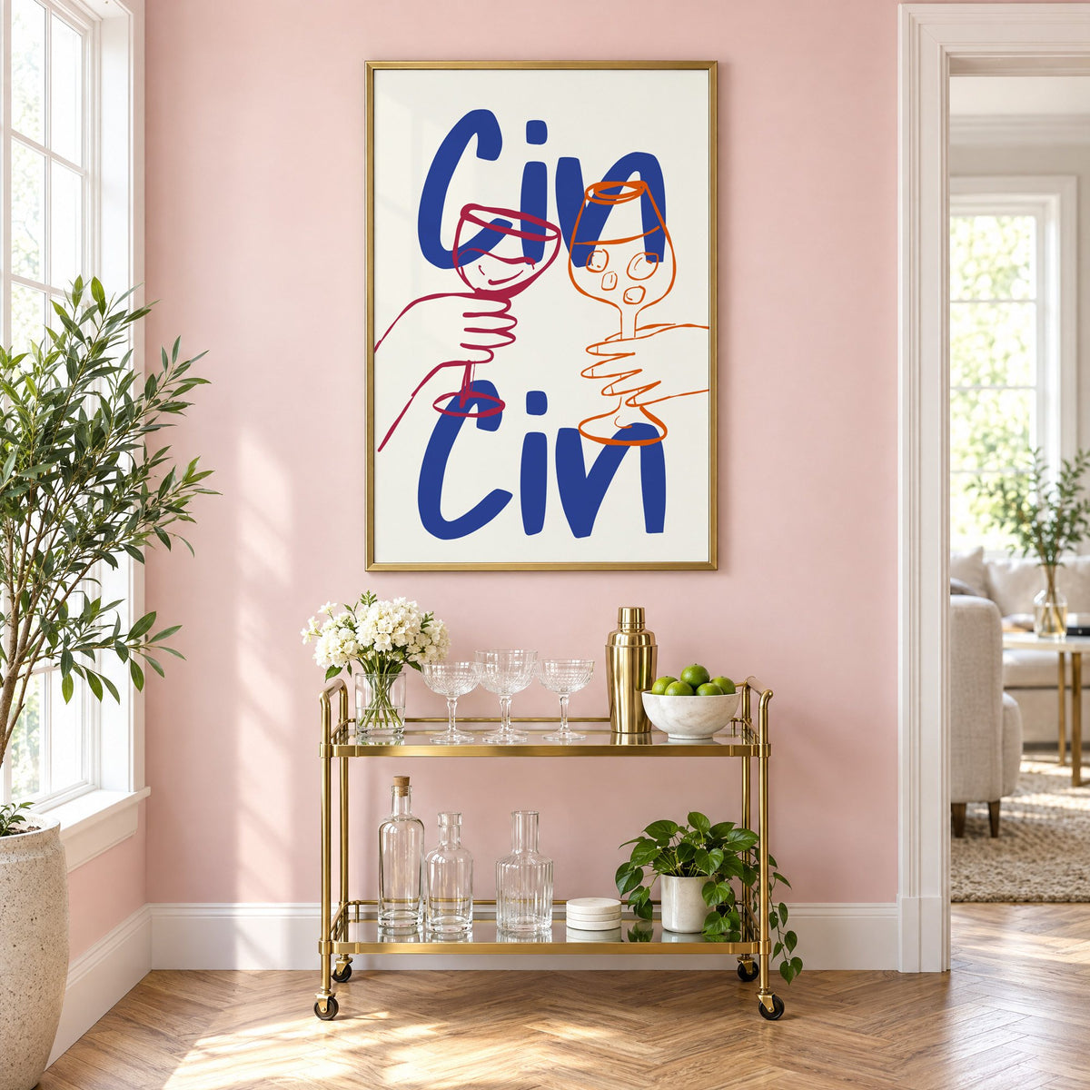 Cin Cin cobalt blue toast print in a brass frame above a gold bar cart on a blush pink wall