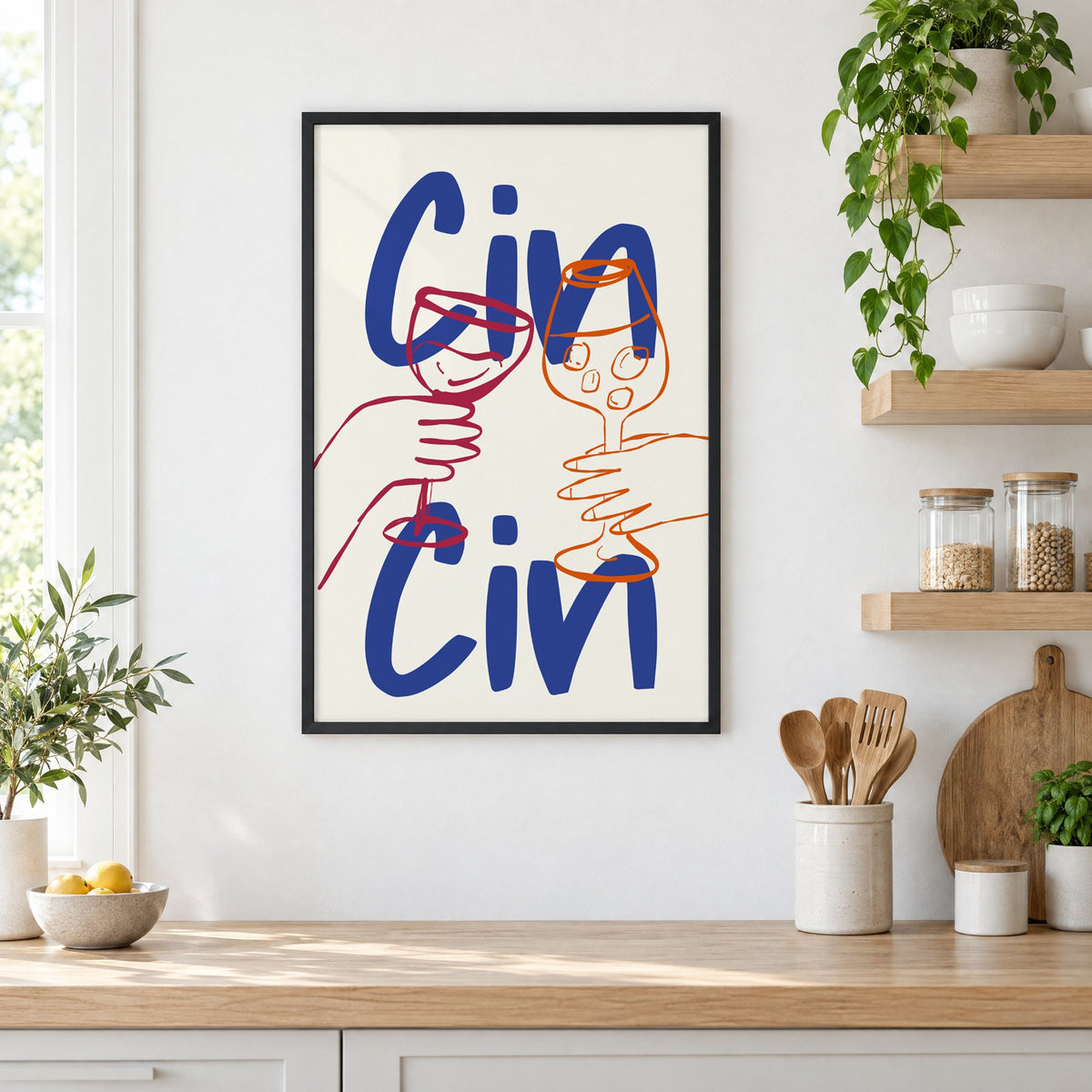 Cin Cin cobalt blue toast print in a black frame in a white kitchen beside open wood shelves and glass jars