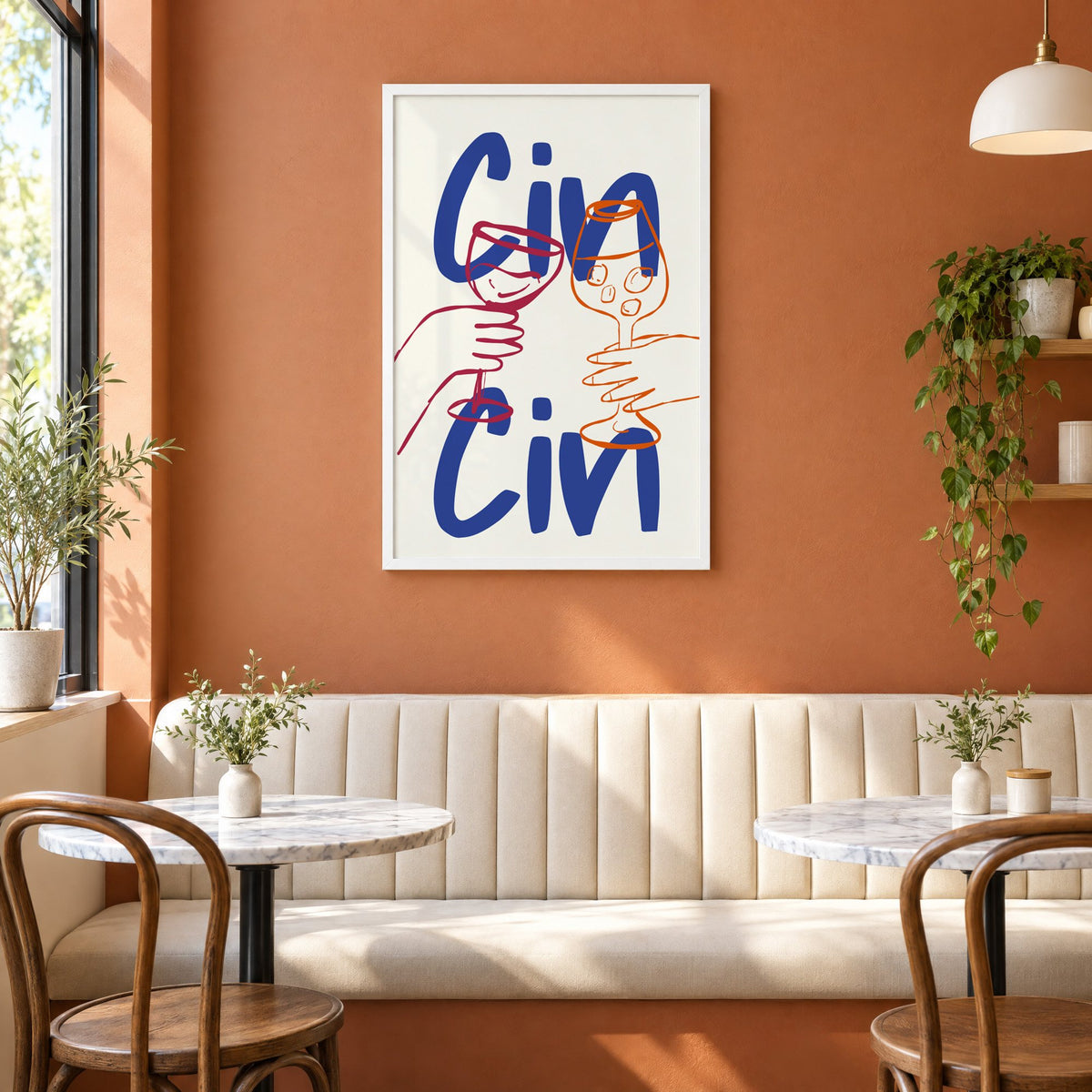 Cin Cin cobalt blue toast print in a white frame above a cream banquette on a terracotta cafe wall