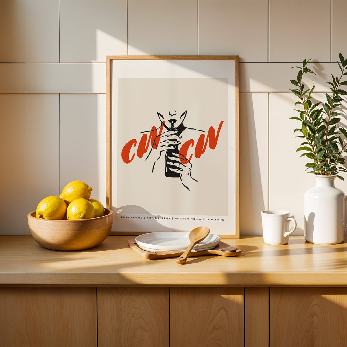Cin Cin champagne print in a slim oak frame beside a wooden bowl of lemons