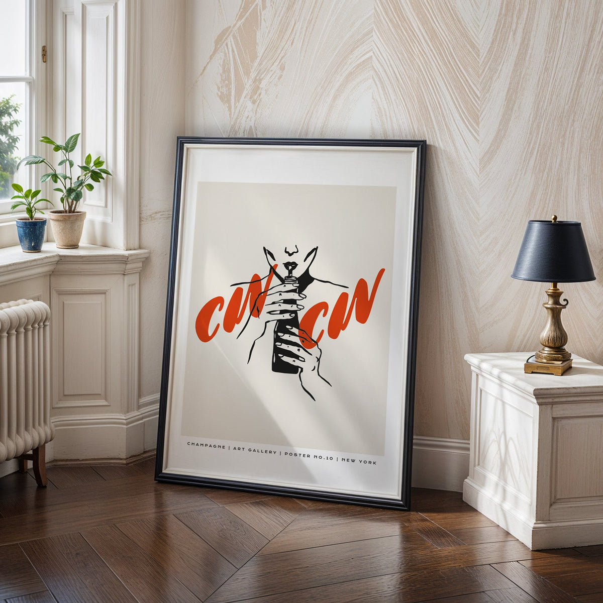 Cin Cin champagne print in a black frame on a dark herringbone floor by a radiator