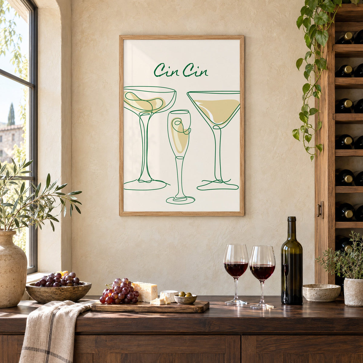 Cin Cin continuous line cocktail glasses print in an oak frame on a limewashed wall above a wine counter with red wine, cheese and grapes