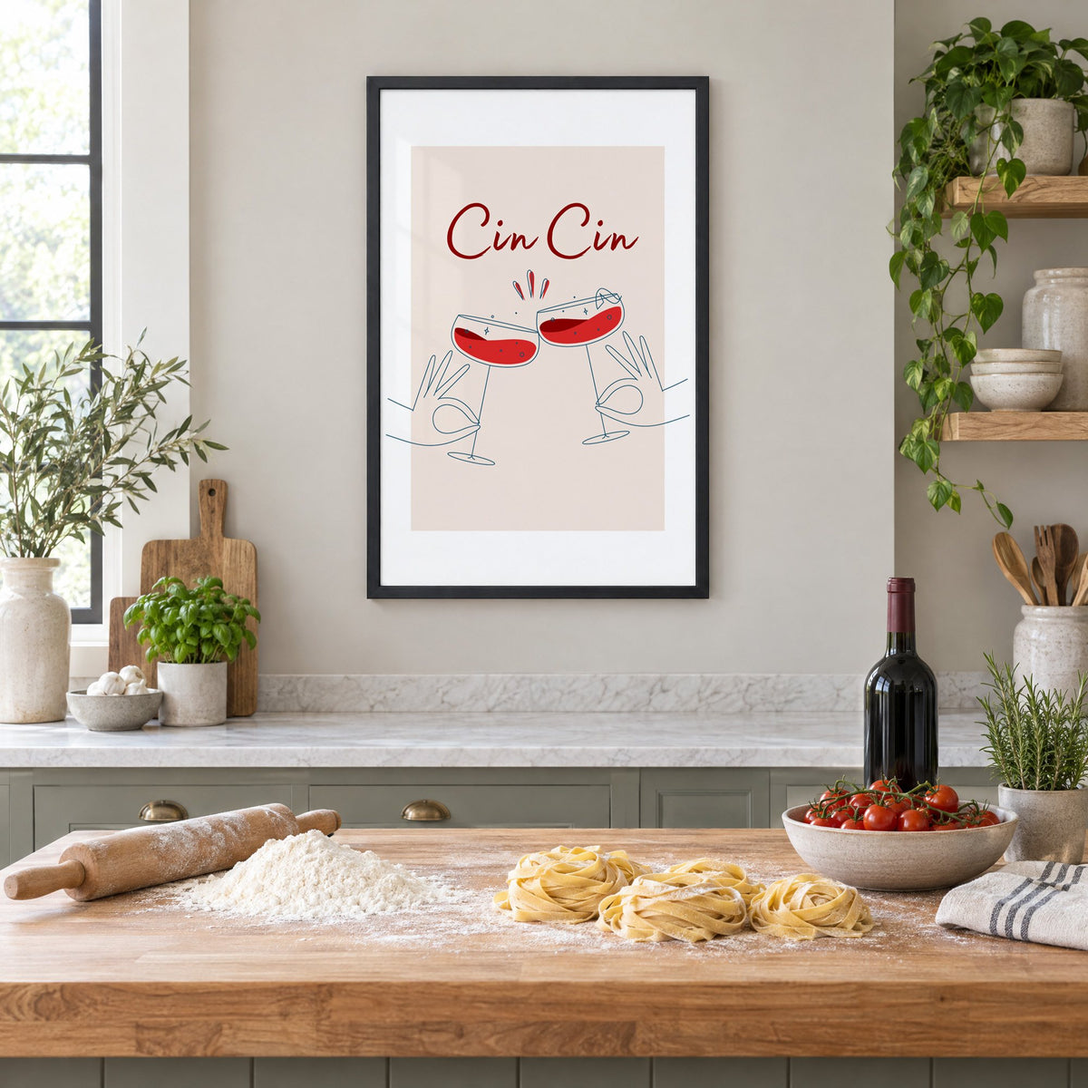 Cin Cin script two hands clinking red coupes print in a black frame above a butcher-block island with fresh pasta, flour and cherry tomatoes