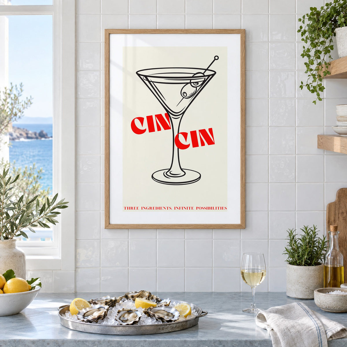CIN CIN red type martini olives print in an oak frame on white tiles above a marble counter with oysters and lemons by a sea view