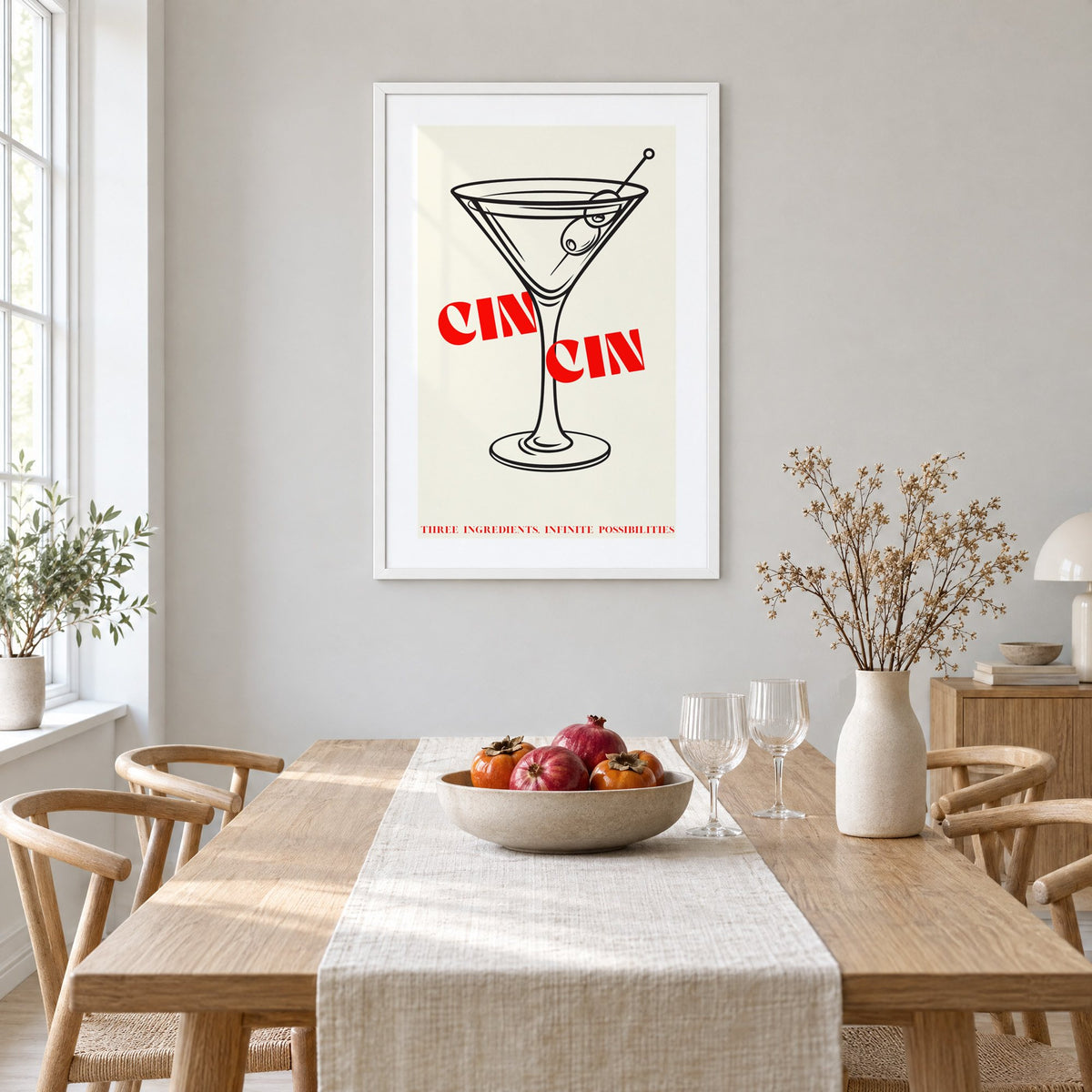 CIN CIN red type martini olives print in a white frame above a light oak dining table with a linen runner and fruit bowl