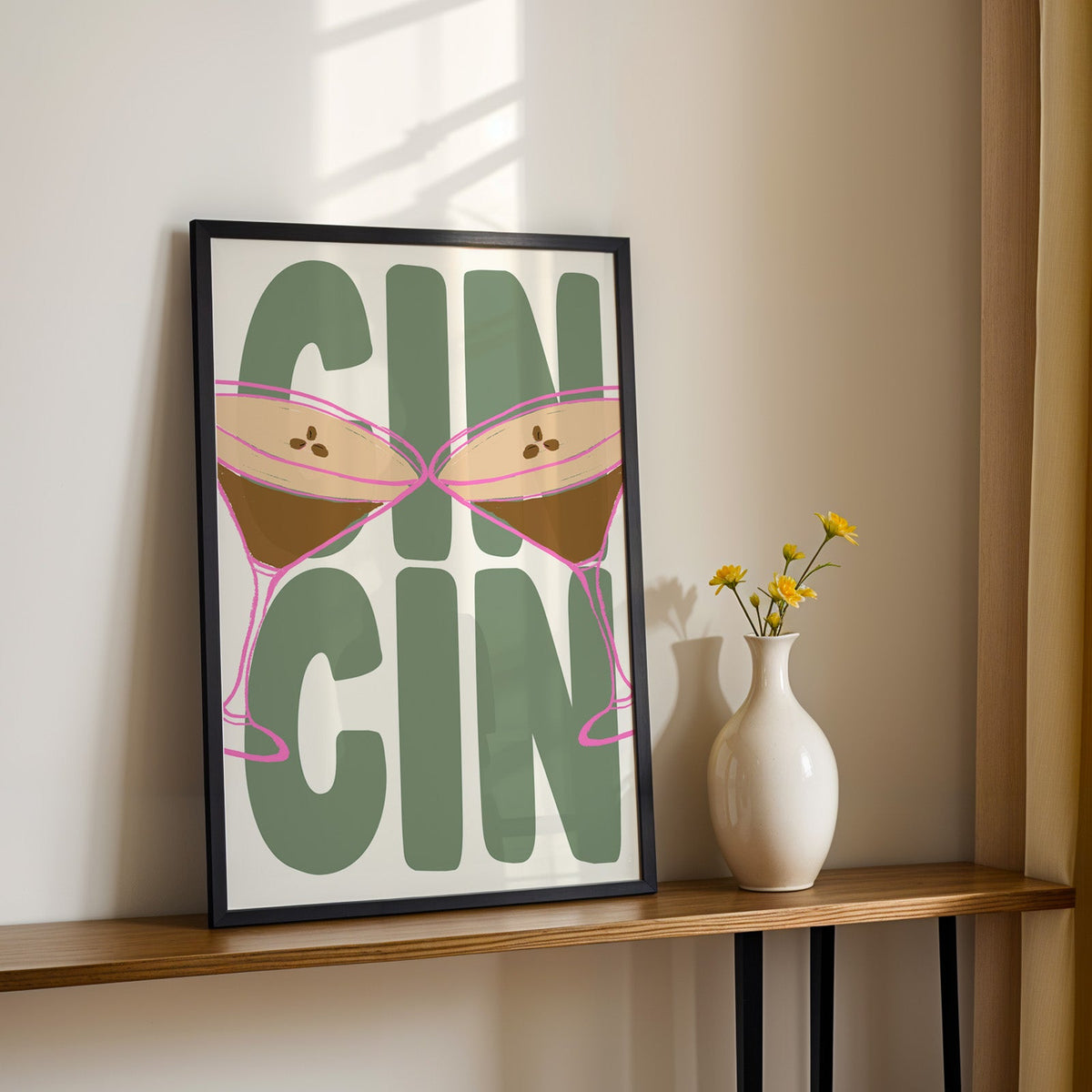 Cin cin espresso martini print in a black frame on a console with yellow daisies