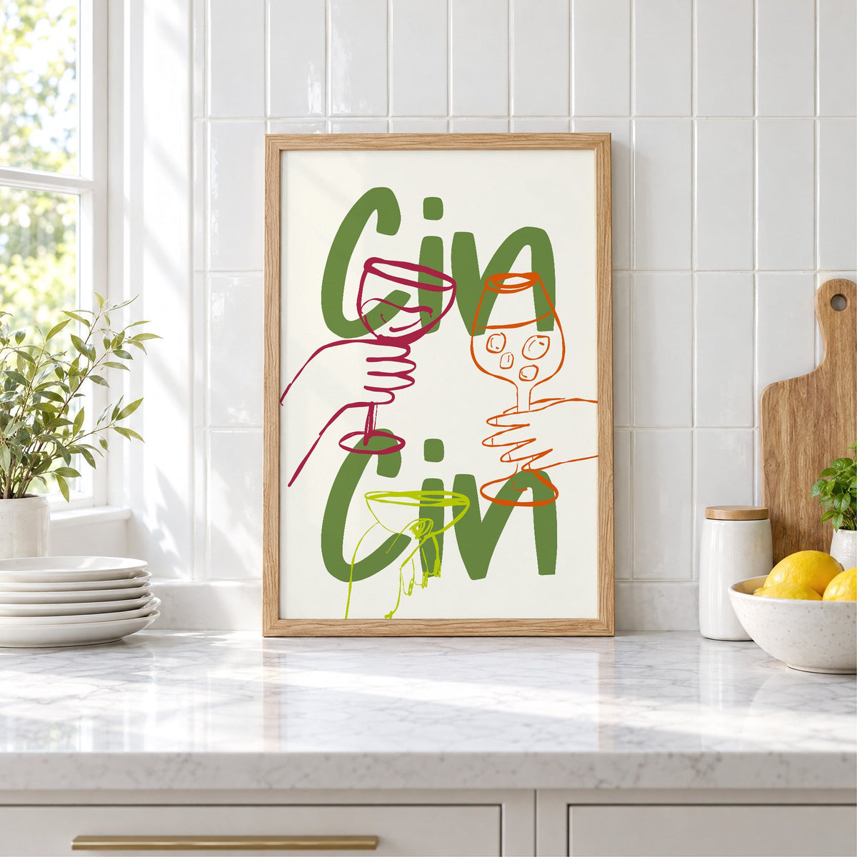 Cin Cin olive green three glasses print in an oak frame leaning on a marble counter by white tiles and lemons