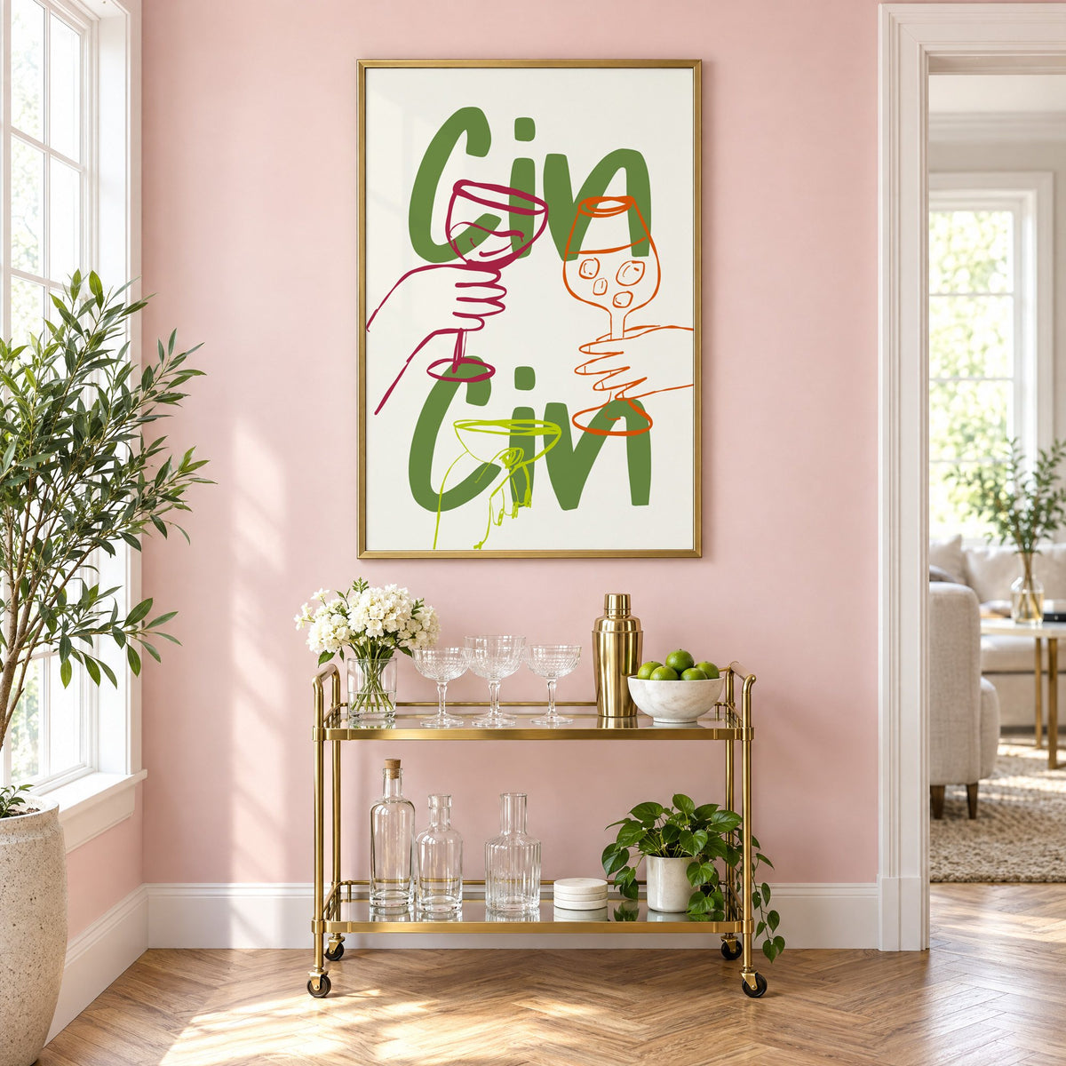 Cin Cin olive green three glasses print in a brass frame above a gold bar cart on a blush pink wall