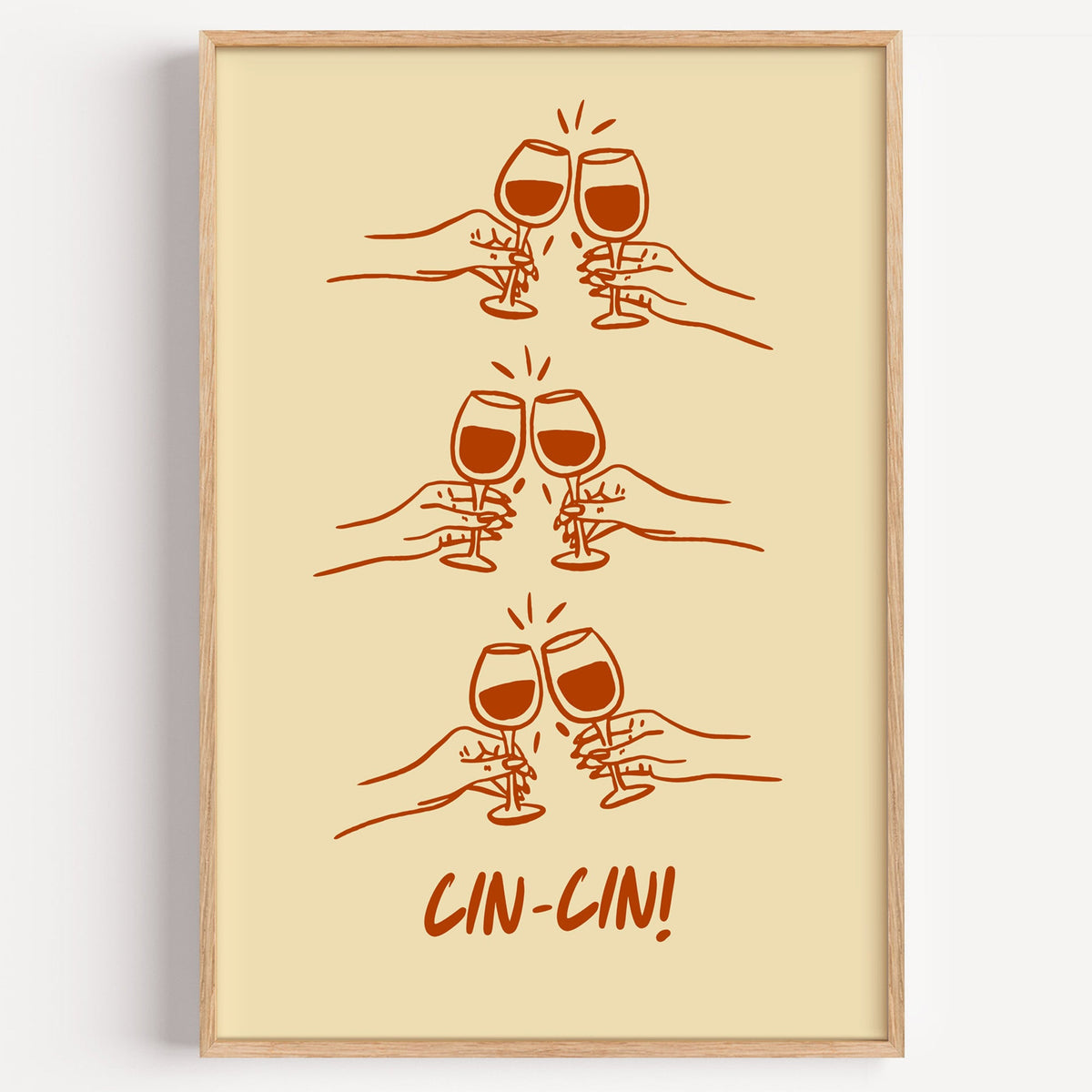 Cin Cin toasting hands print in a light oak frame on a plain white wall
