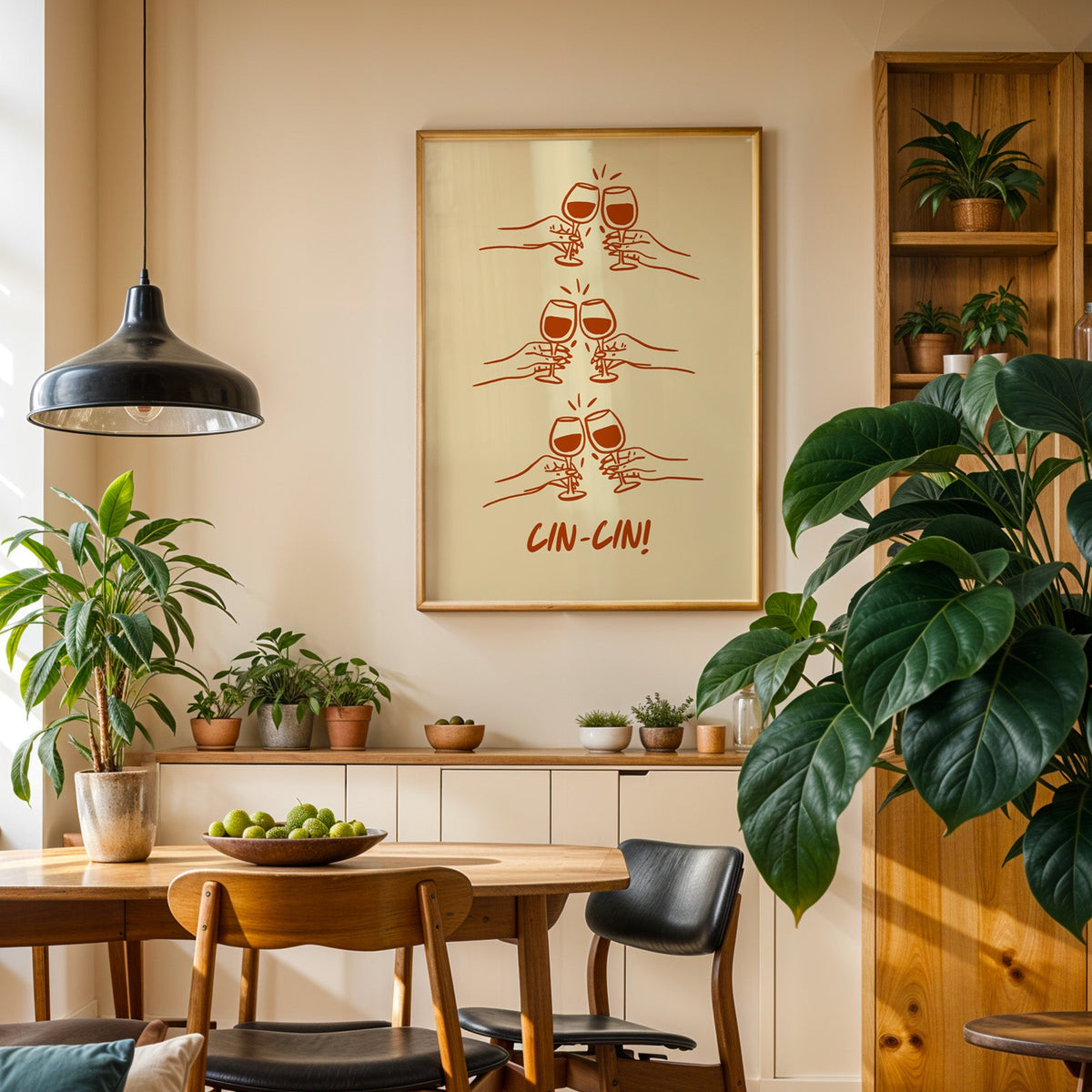 Cin Cin toasting hands print in an oak frame in a dining room above a plant-lined sideboard