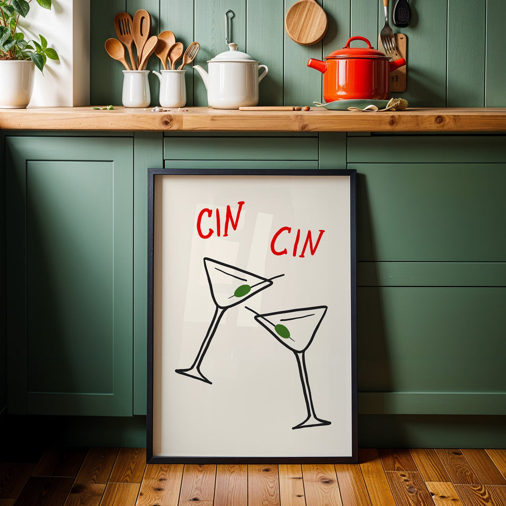 Cin cin olive martini print in a black frame against sage green cabinets