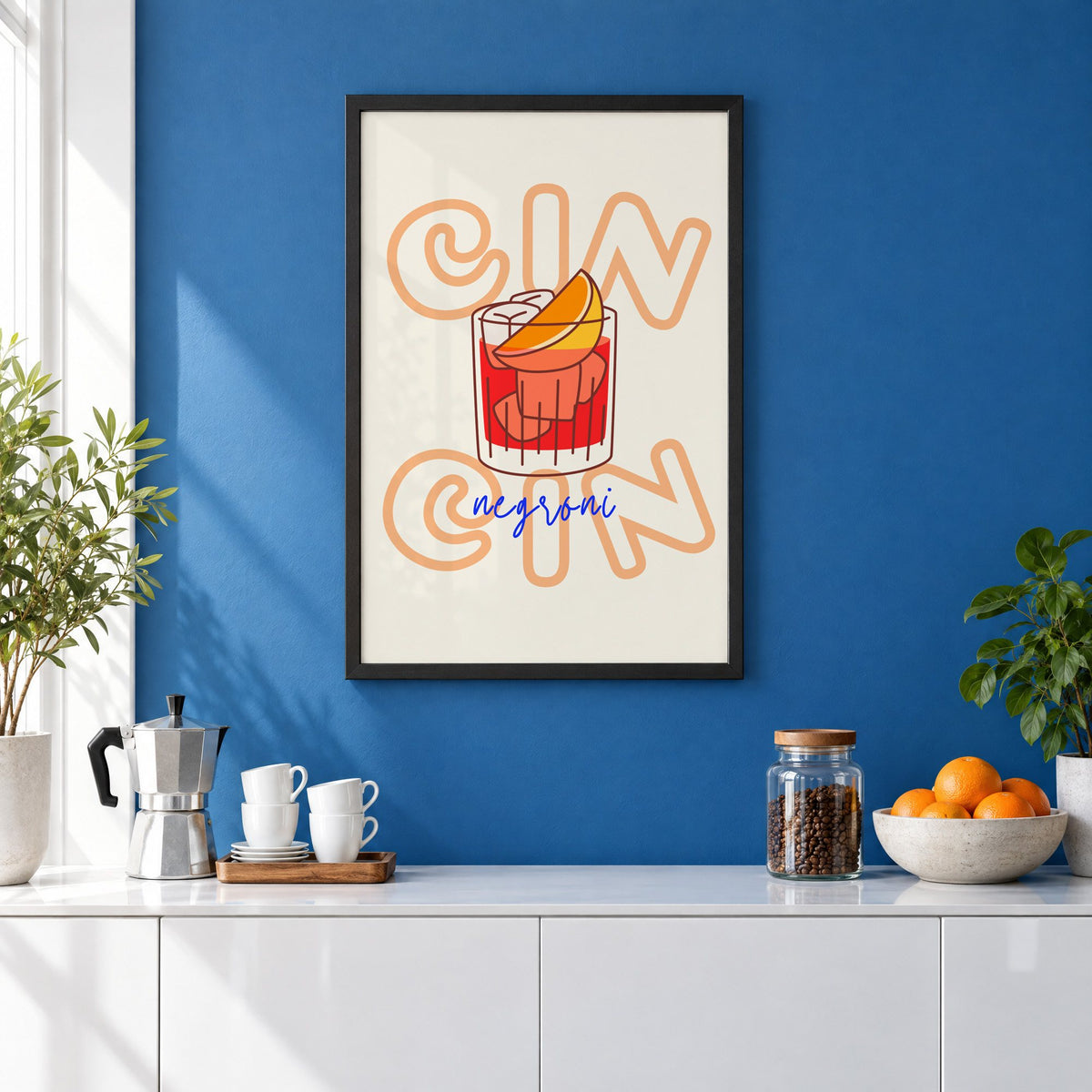 Cin Cin negroni orange slice print in a black frame on a cobalt blue wall above a coffee station