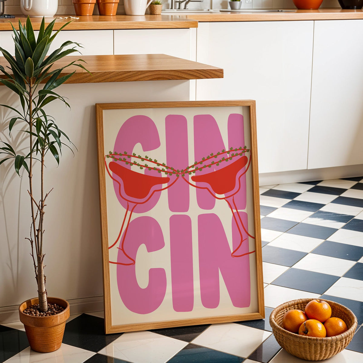 Cin cin pink coupe print in an oak frame by a kitchen island and tiled floor