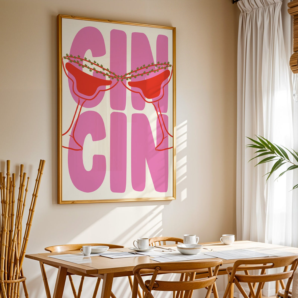 Cin cin pink coupe print in a gold frame above a sunlit breakfast table