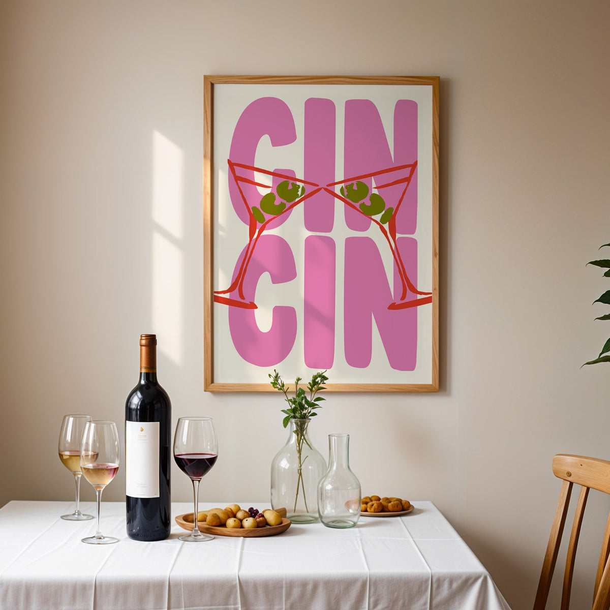 Cin cin red martini print in an oak frame above a table laid with red wine and glasses