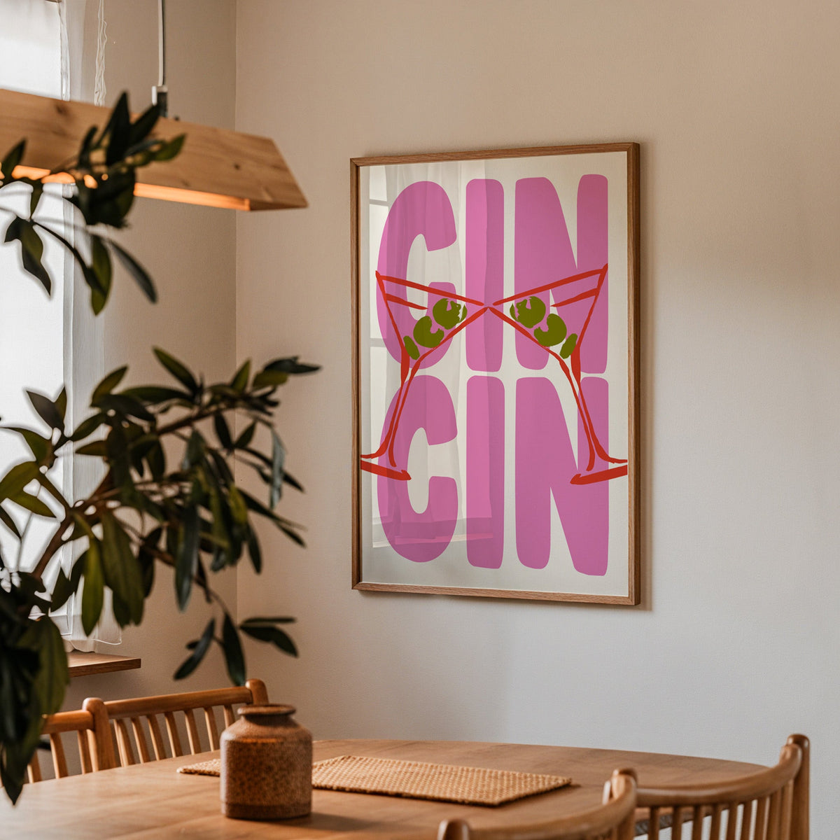 Cin cin red martini print in a walnut frame above a dining table beside an olive tree