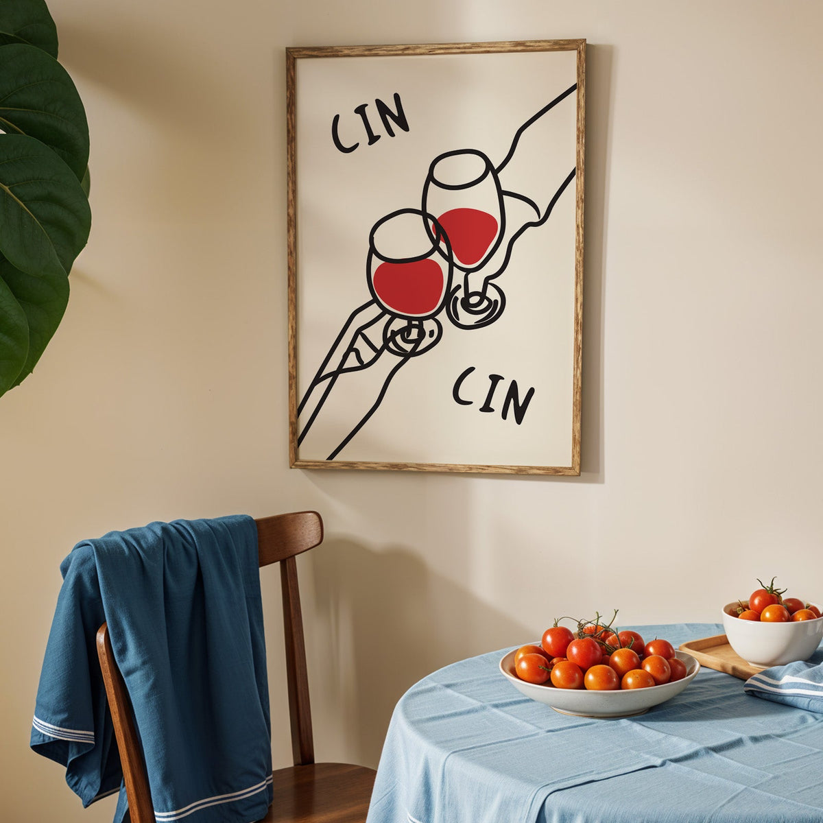Cin cin red wine line art print in an oak frame above a blue linen table with ripe tomatoes