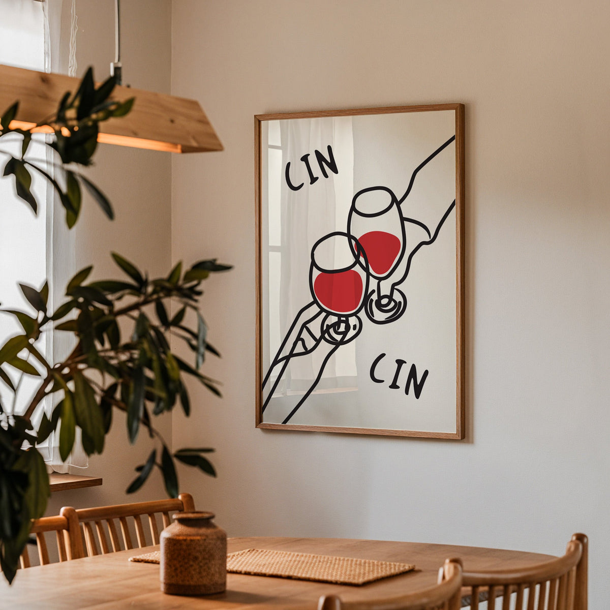 Cin cin red wine line art print in a walnut frame above a dining table beside an olive tree