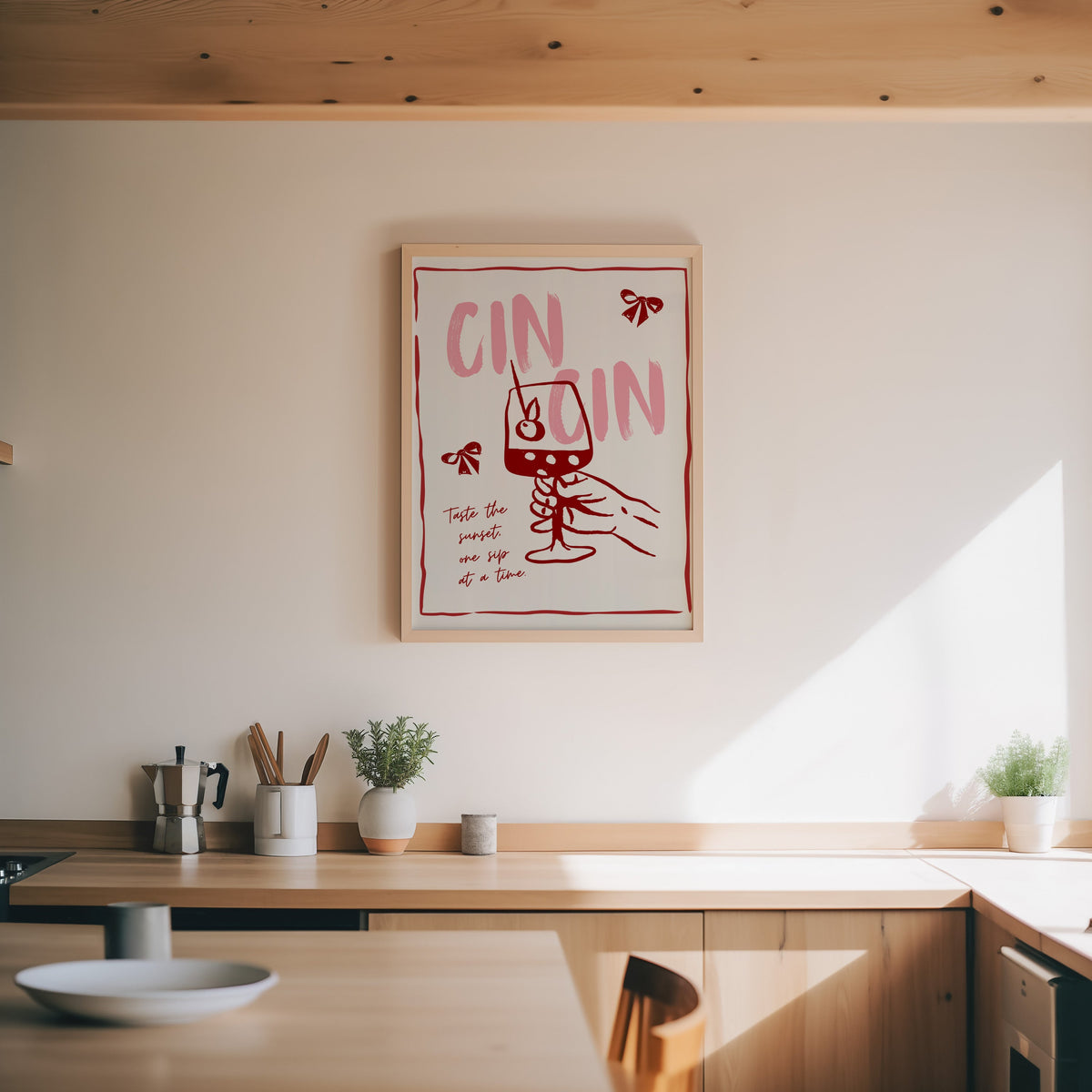 Cin Cin wine print in an oak frame above a wood counter with a moka pot and herbs