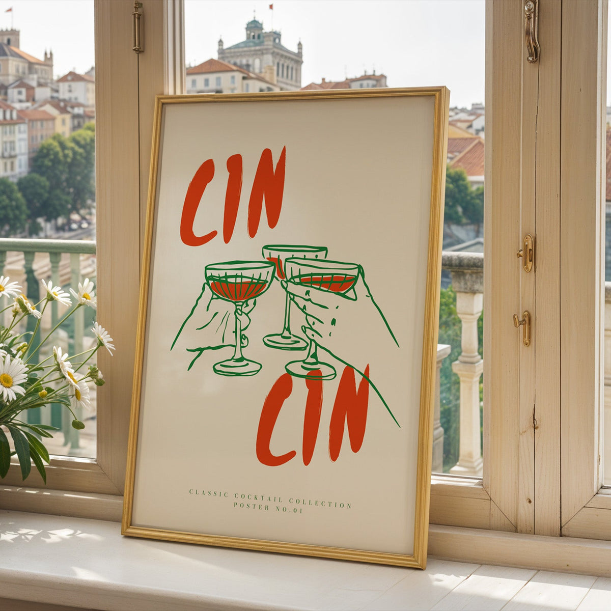 Cin Cin three coupes print in a gold frame on a window sill above a hillside town