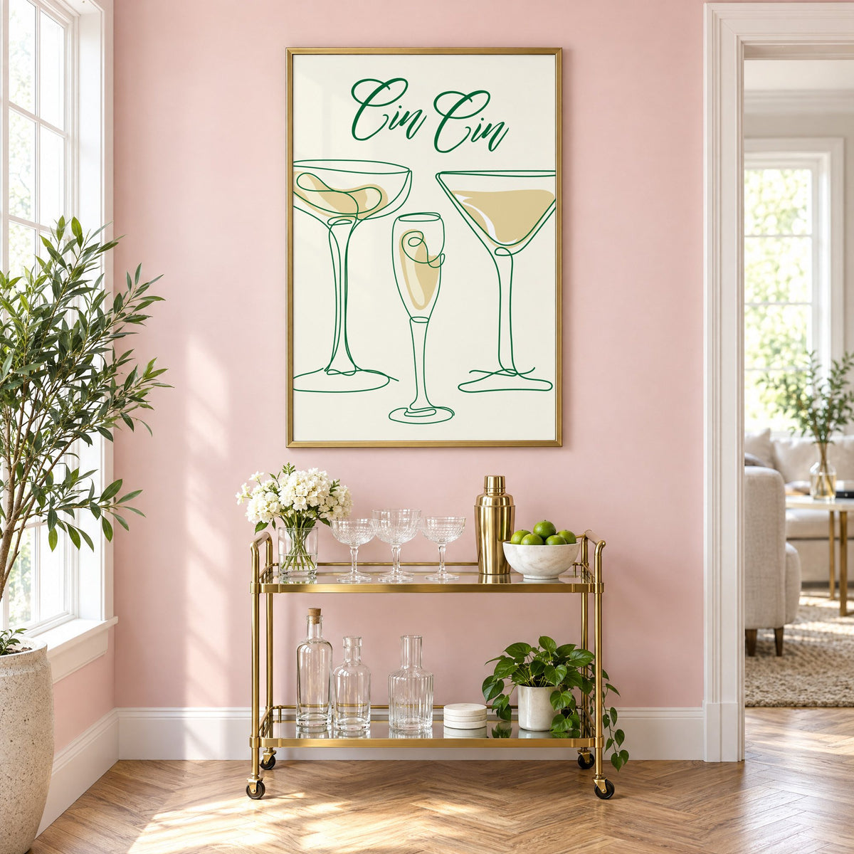 Cin Cin one-line coupe, flute and martini print in a brass frame on a blush pink wall above a gold bar cart with glassware