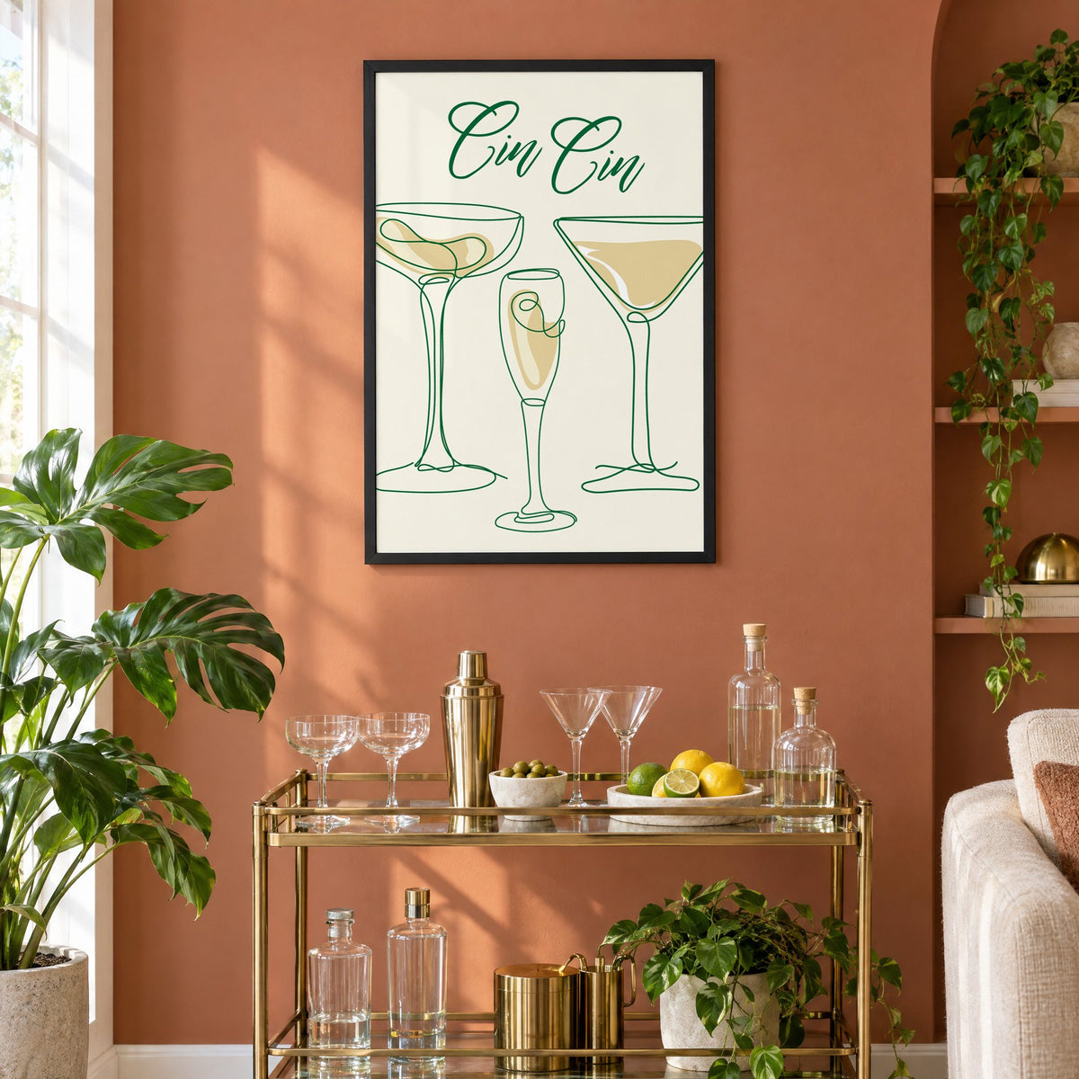 Cin Cin one-line coupe, flute and martini print in a black frame on a terracotta wall above a brass bar cart with coupes and citrus